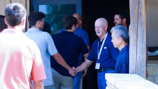 A group of people are standing in a line holding hands.