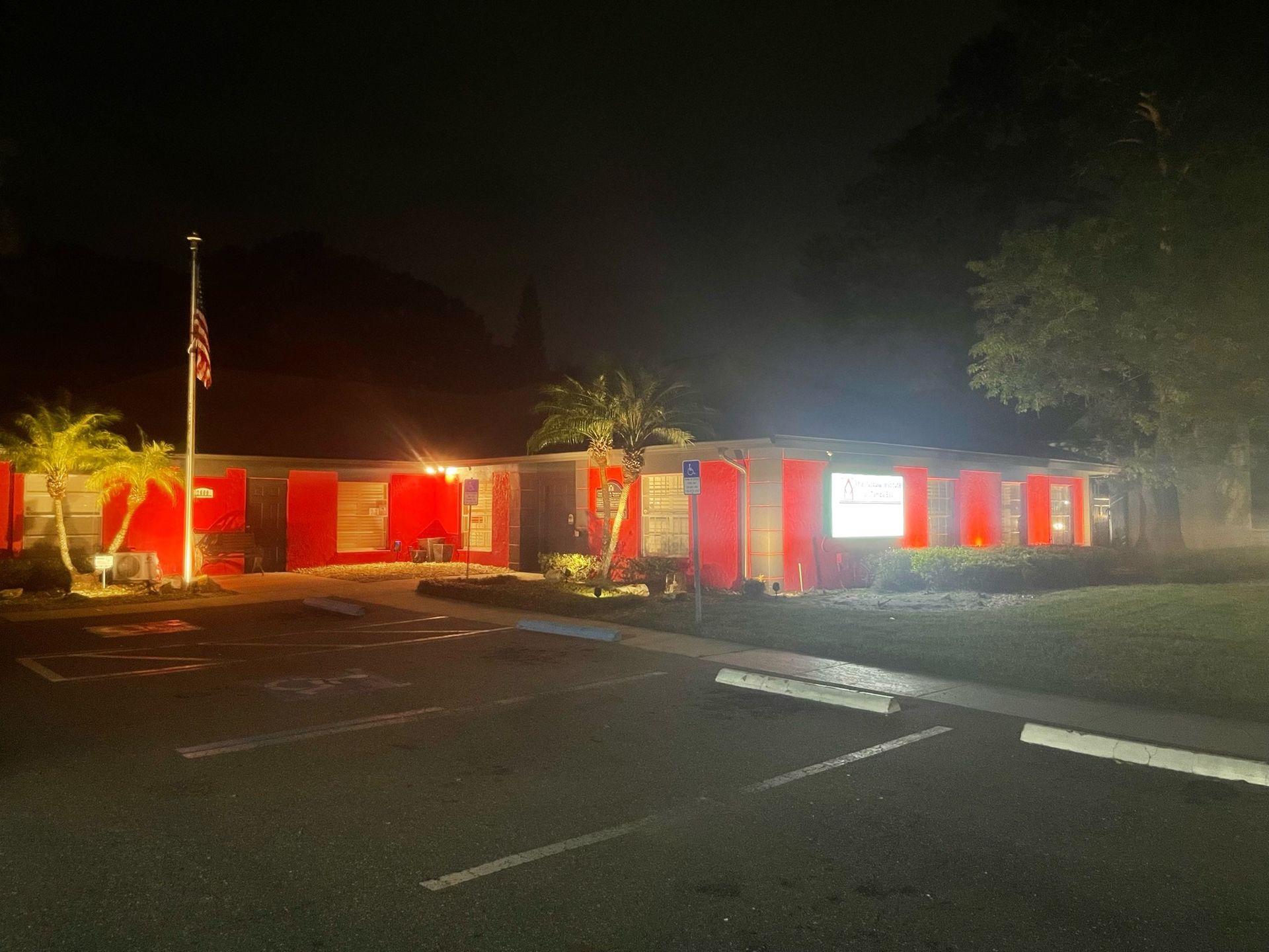 A red and white building is lit up at night.