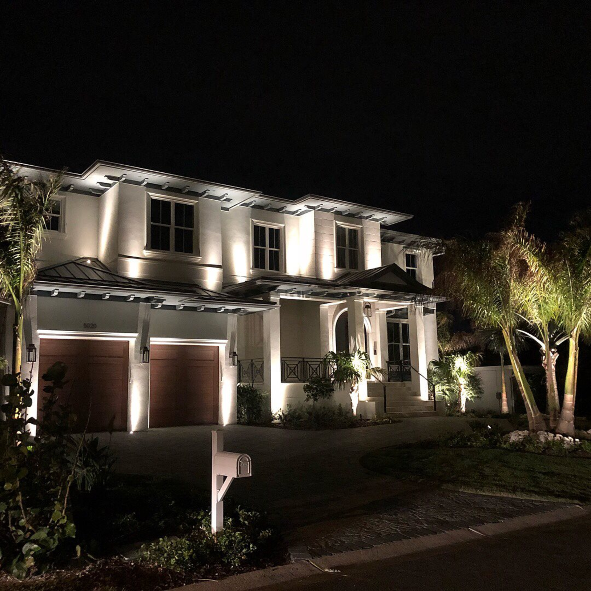 A large white house is lit up at night