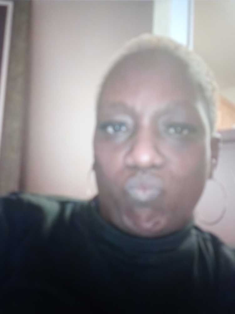 A woman in a black shirt is taking a selfie