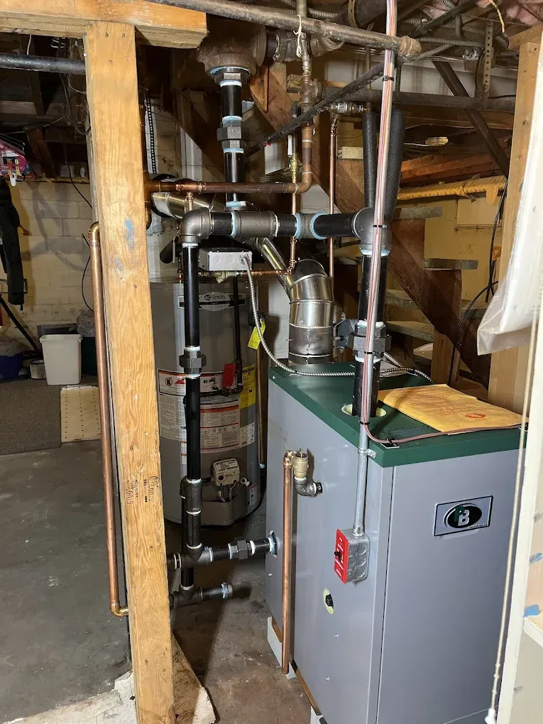 Heating system with pipes and a boiler in a basement setting.
