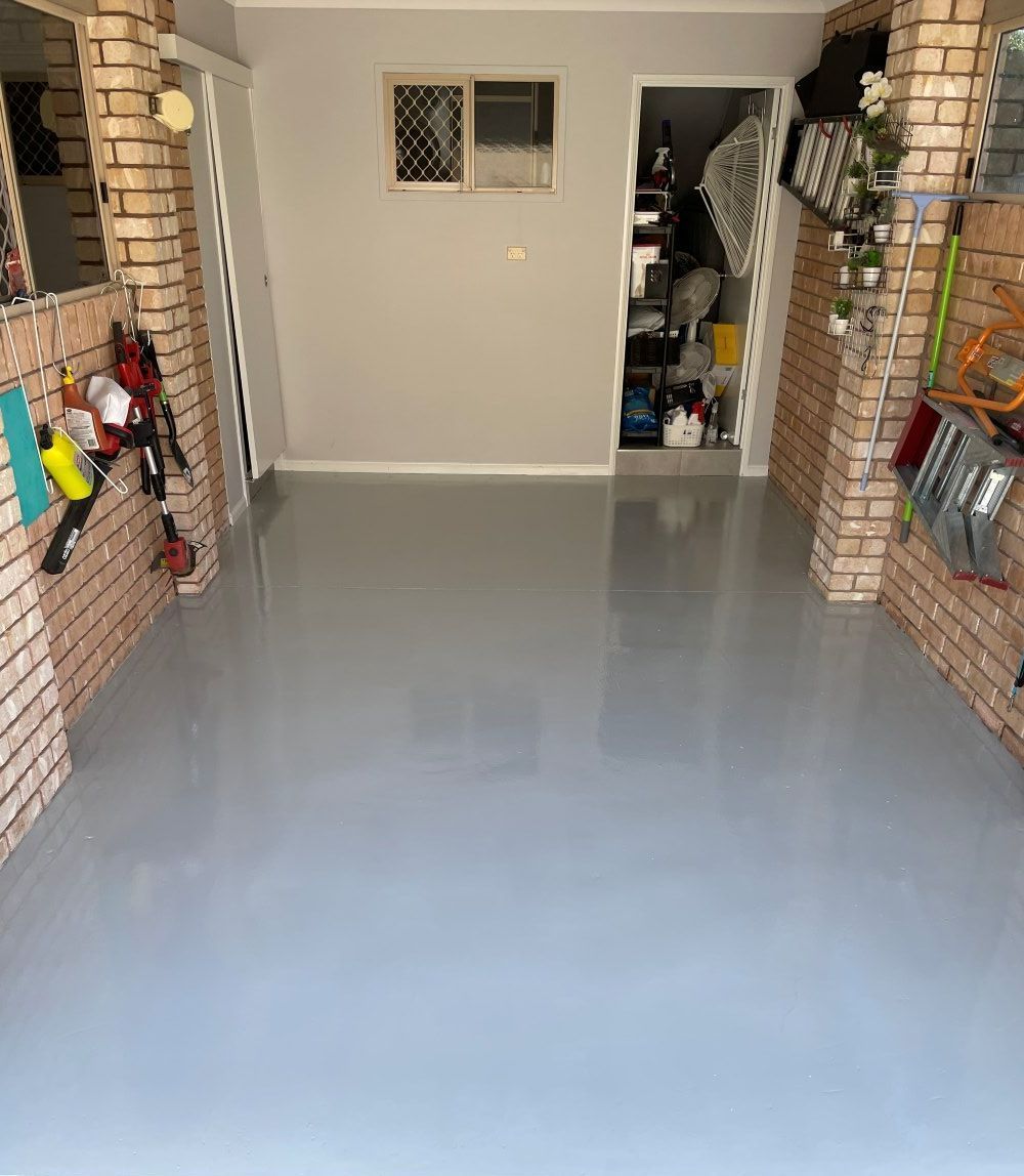 A Garage With An Epoxy Floor And A Brick Wall — FNQ Maintenance Services In Parramatta Park, QLD