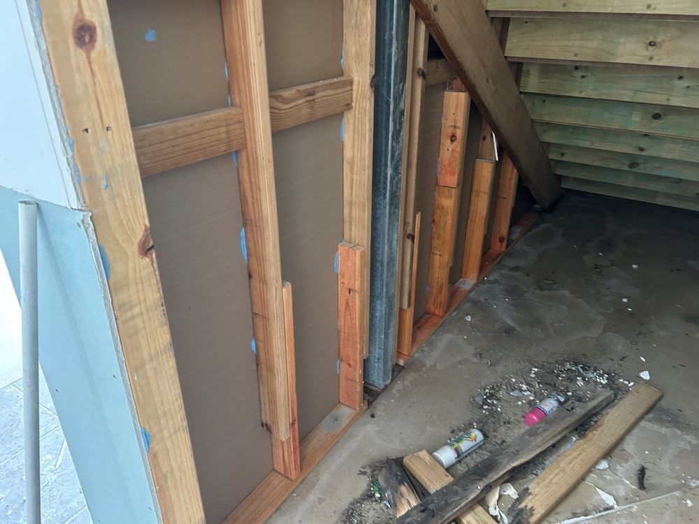 A Wooden Wall Is Being Built Under A Staircase — FNQ Maintenance Services In Parramatta Park, QLD