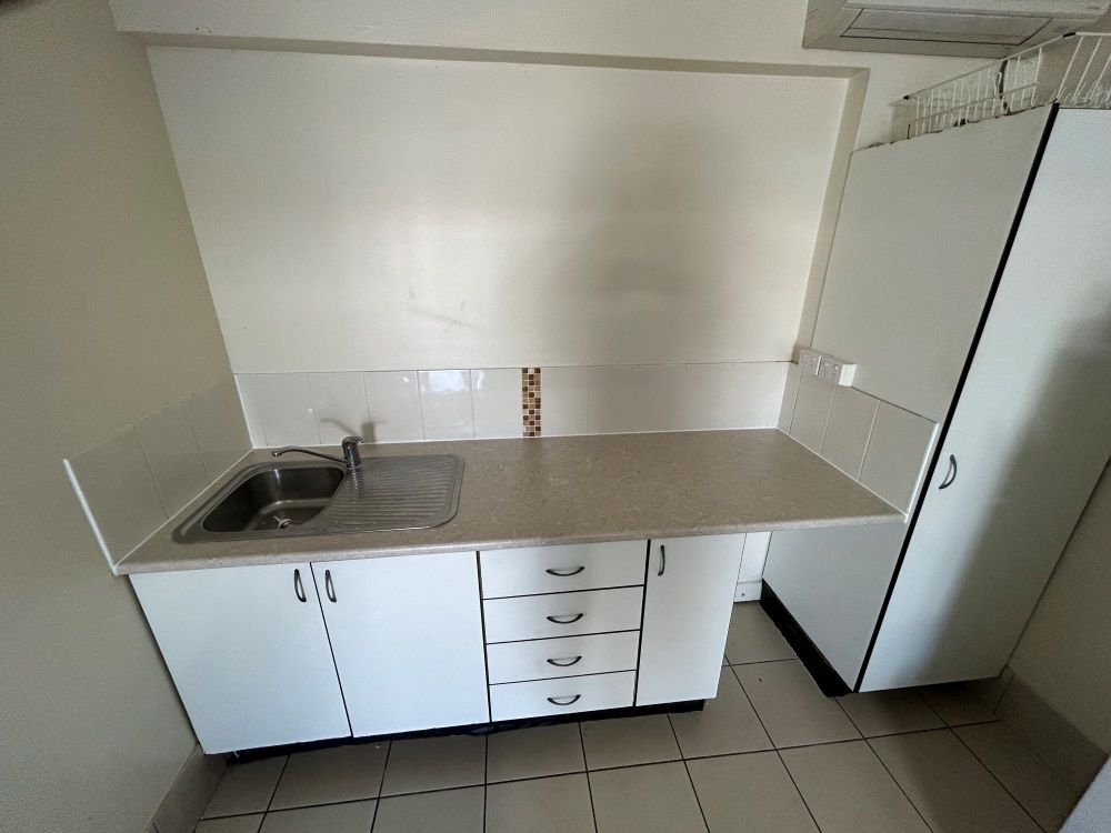 A Kitchen With White Cabinets And A Sink — FNQ Maintenance Services In Parramatta Park, QLD