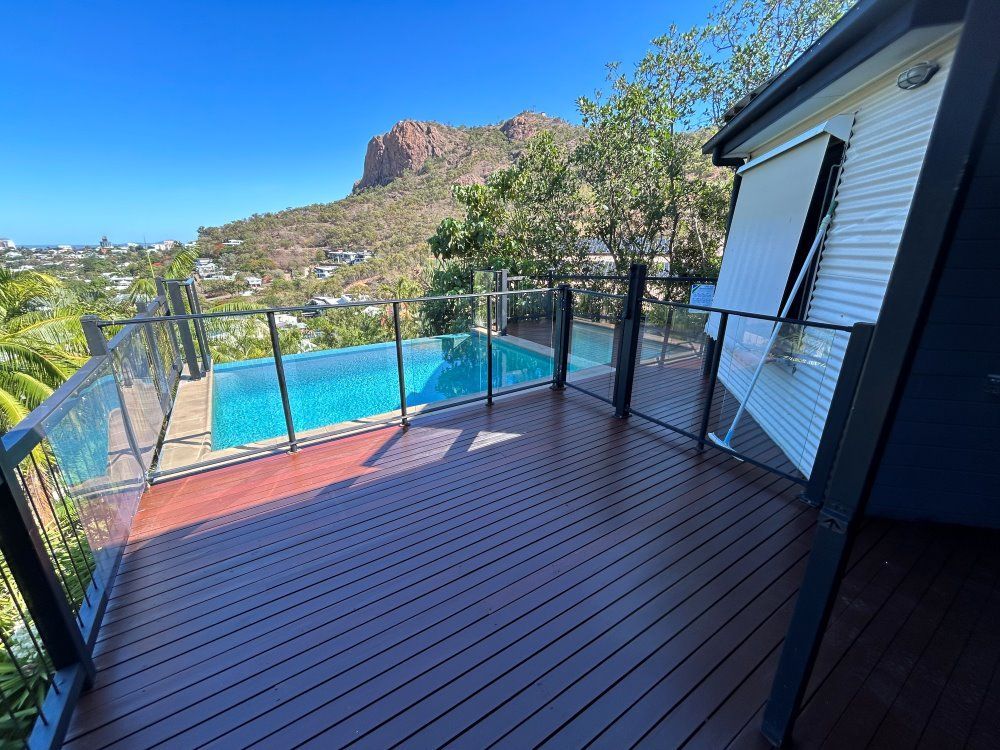 A Deck With A View Of A Swimming Pool And A Mountain — FNQ Maintenance Services In Parramatta Park, QLD