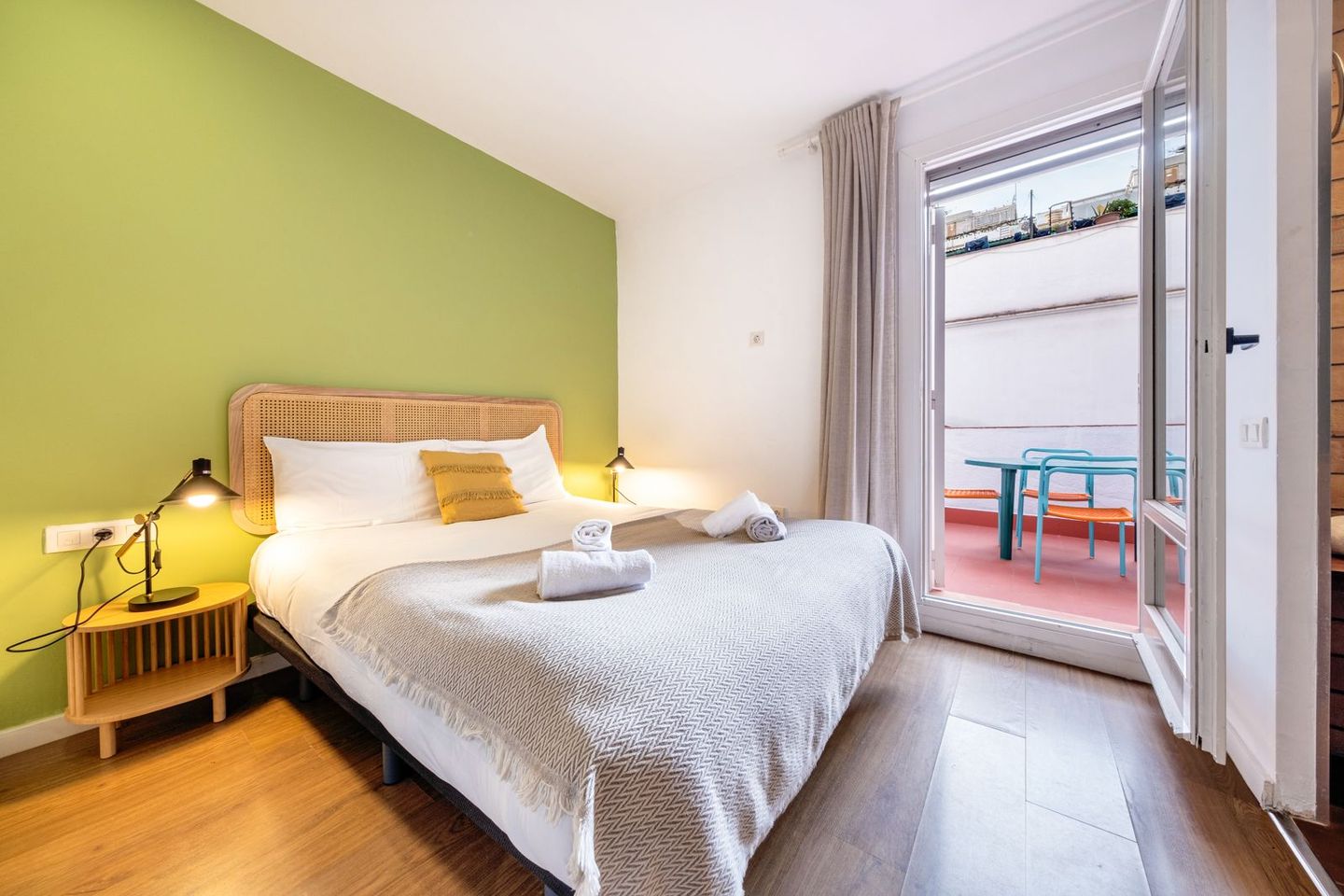 A bedroom with a king size bed and a balcony.