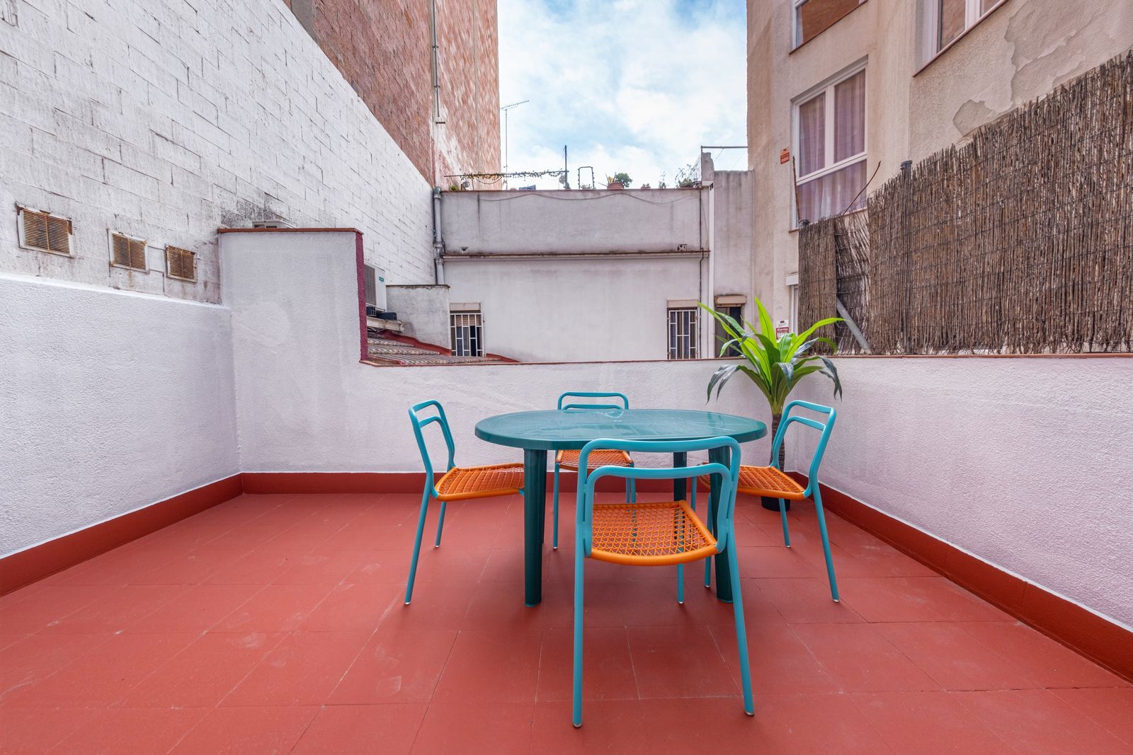 There is a table and chairs on the roof of a building.