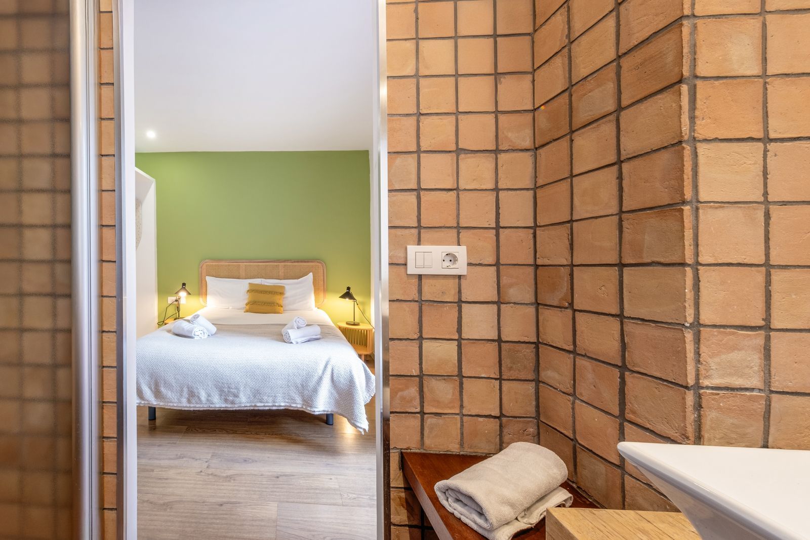 A bedroom with a bed and a bathroom with a sink.