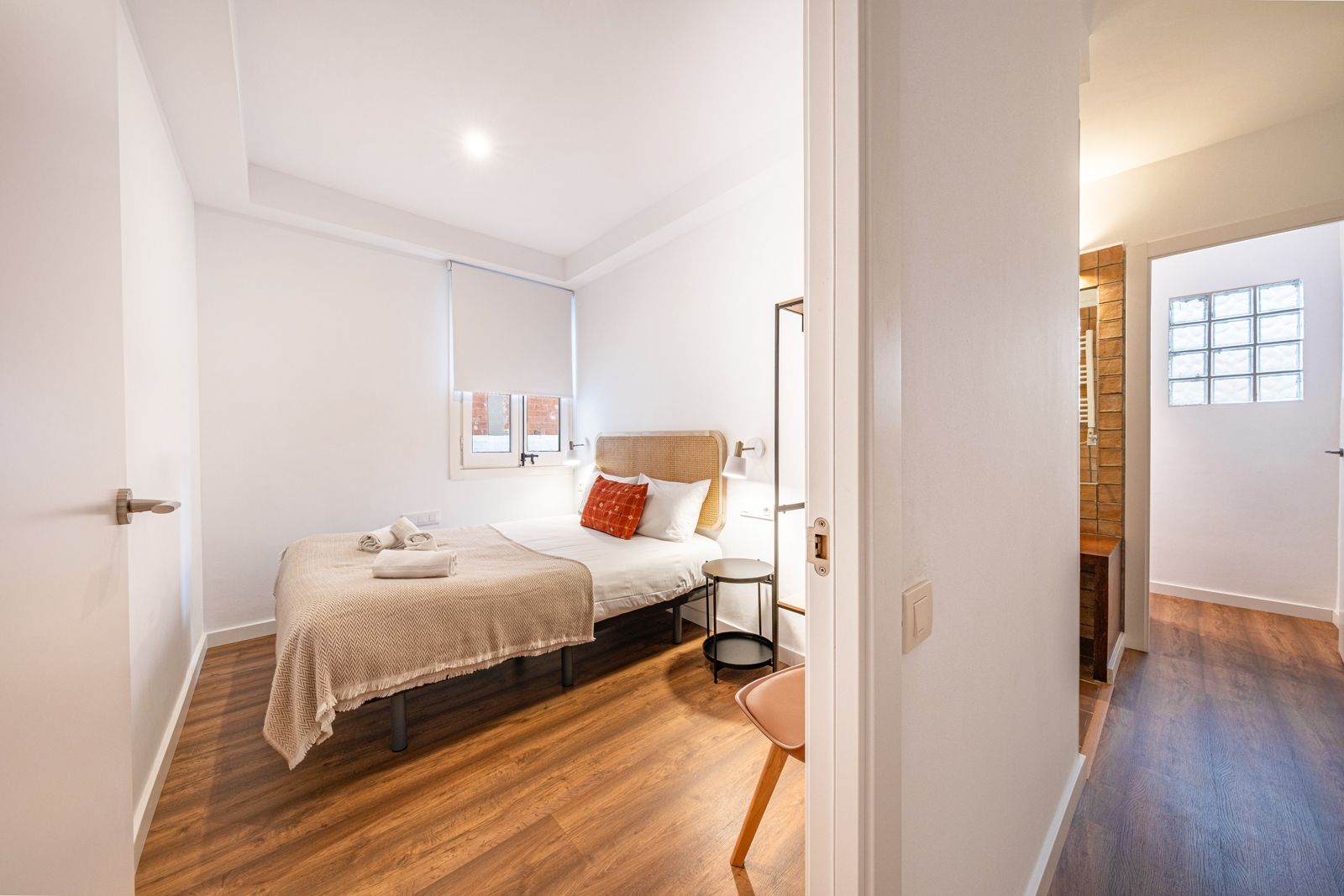 A bedroom with a bed and a chair in it.