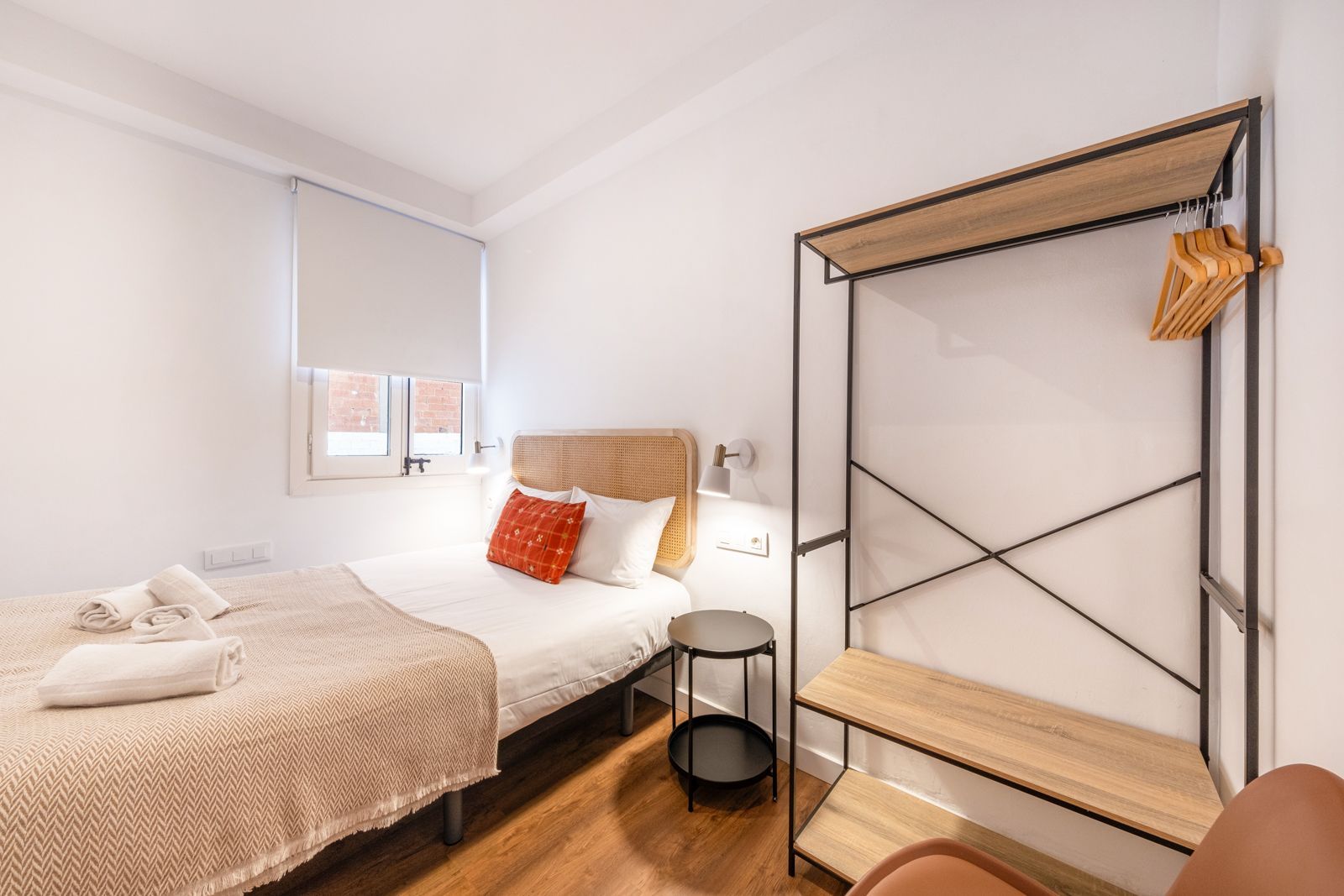A bedroom with a bed , a chair , a table and a wardrobe.