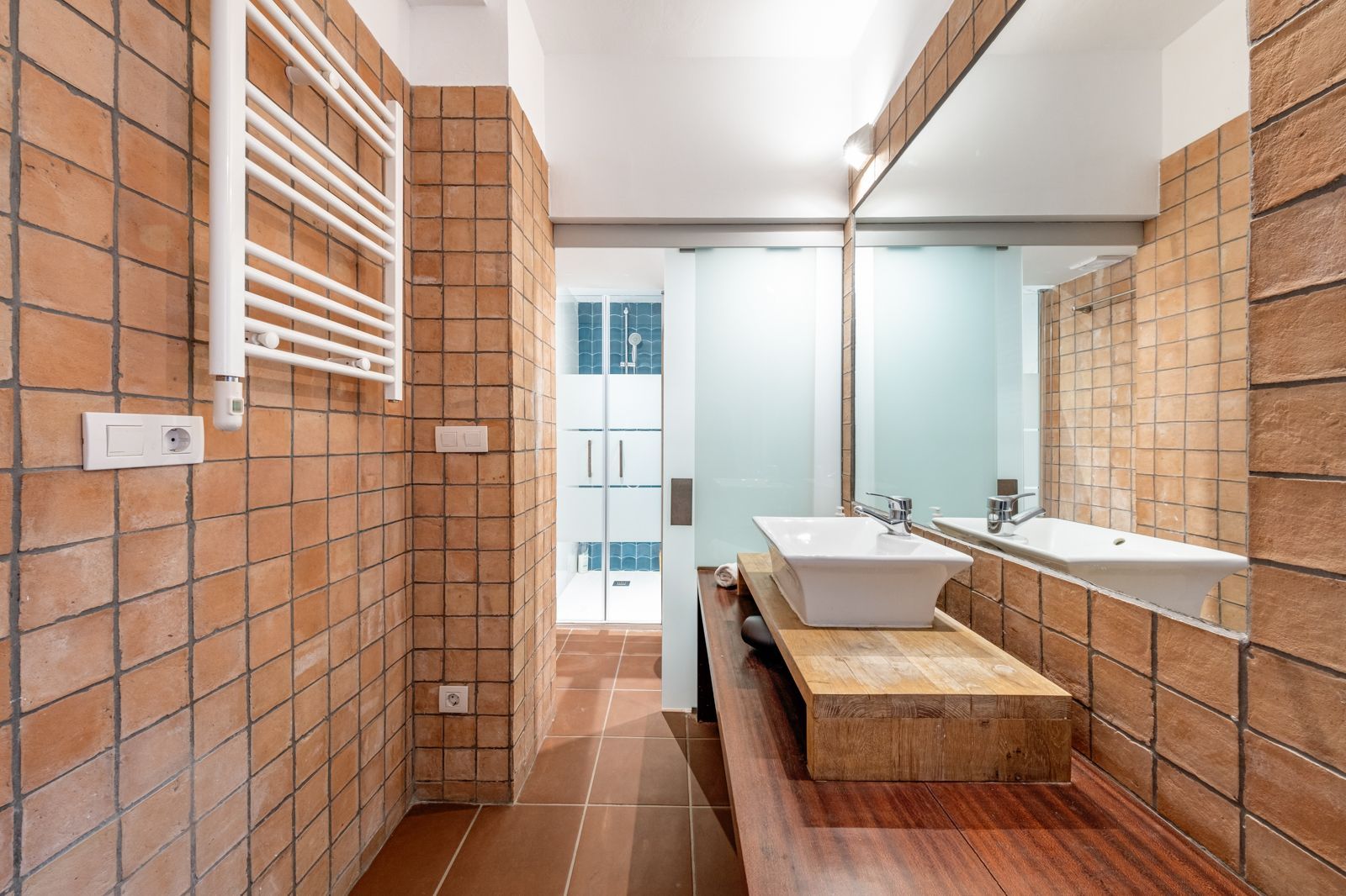 A bathroom with two sinks and a large mirror.
