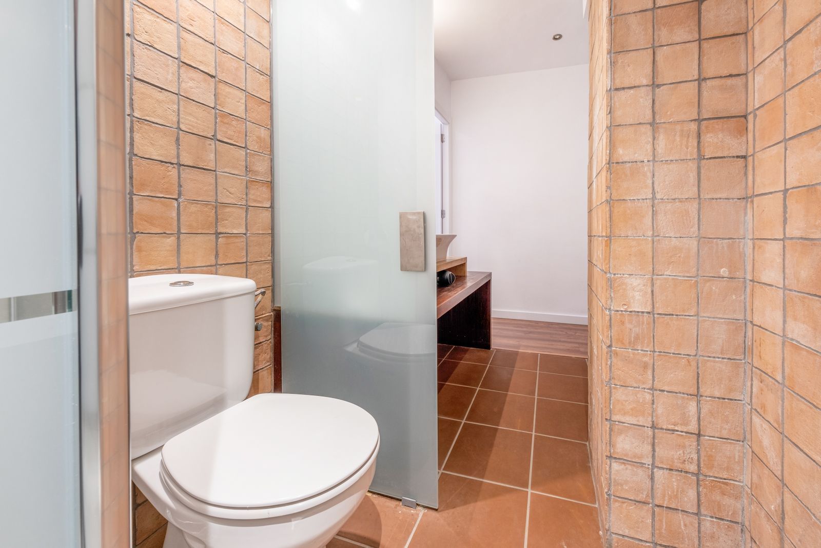 A bathroom with a toilet and a glass shower door.