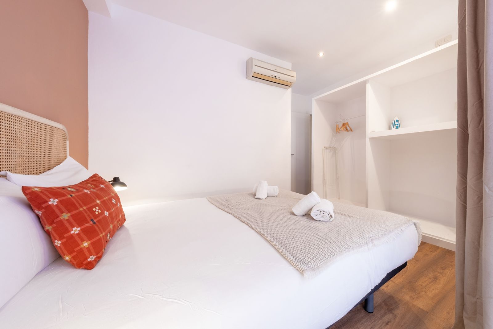 A bedroom with a king size bed and a wicker headboard.