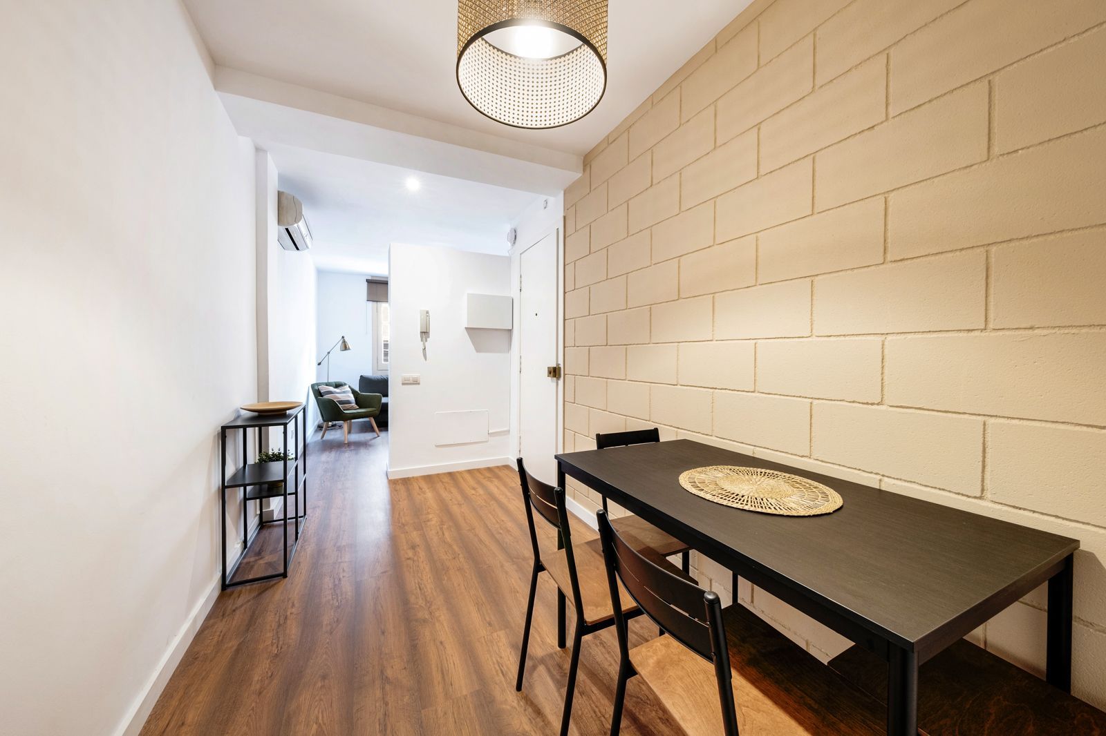 A dining room with a table and chairs and a brick wall.