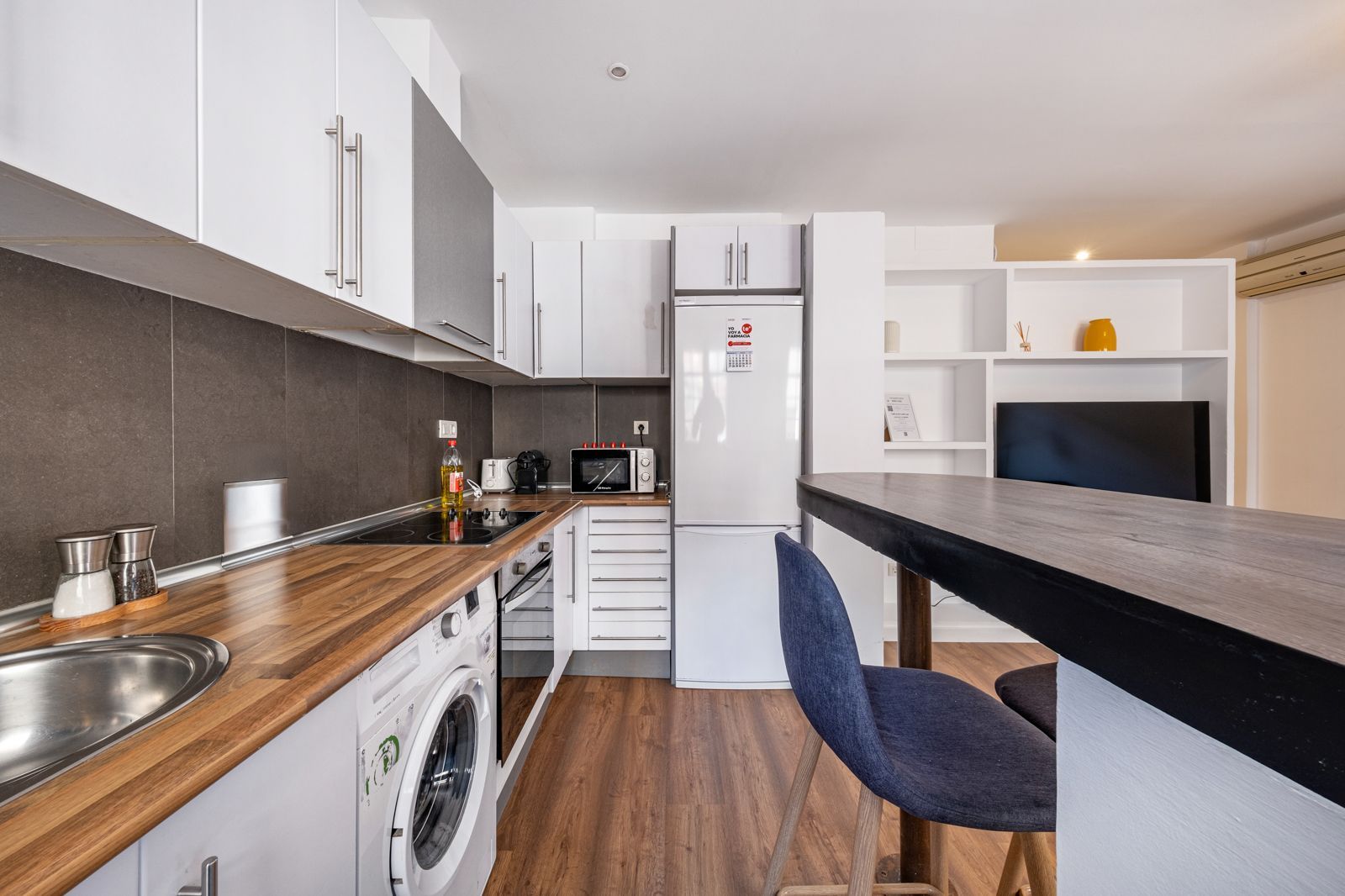 A kitchen with white cabinets and wooden counter tops