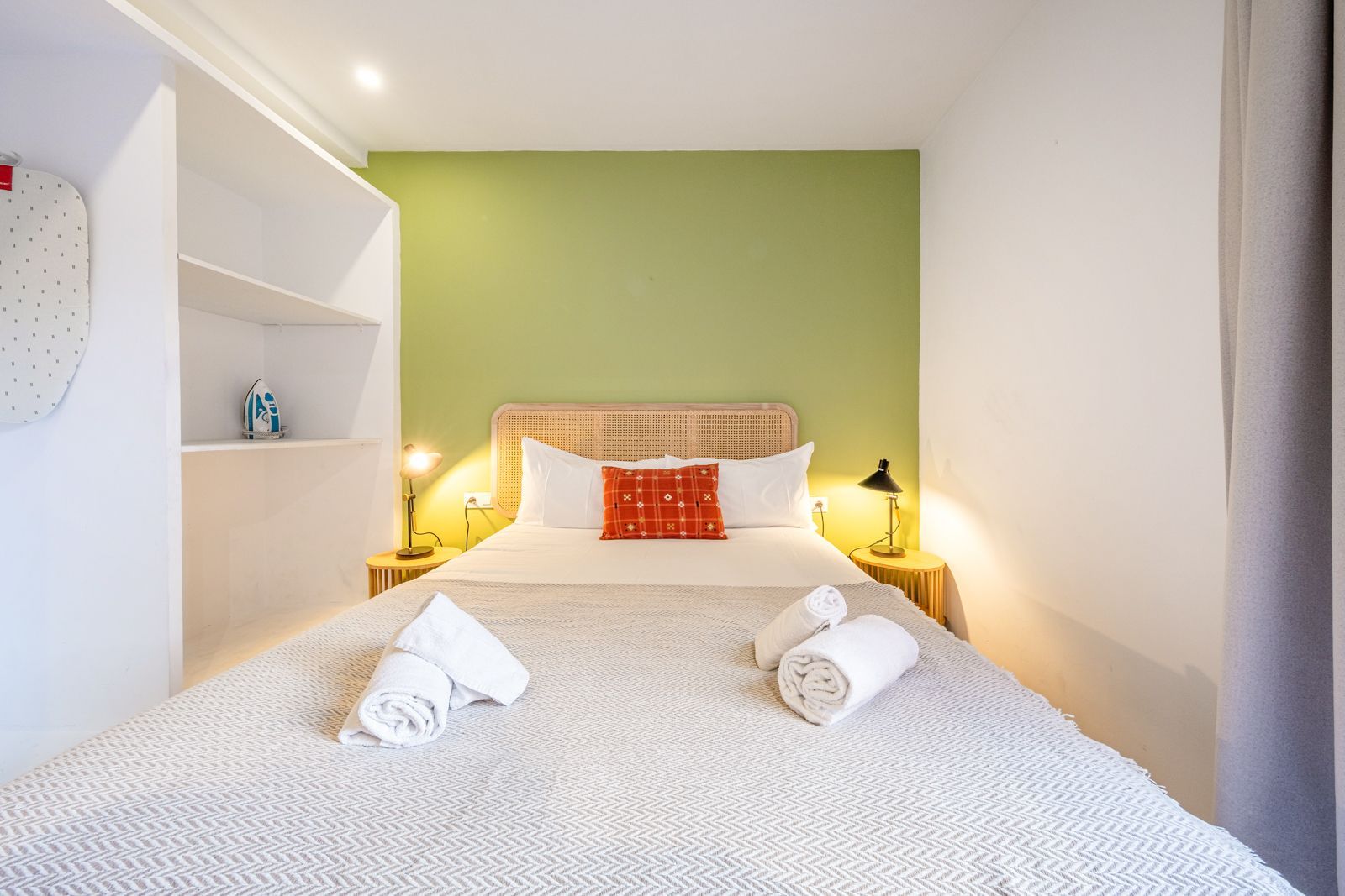A bedroom with a bed and a green wall.