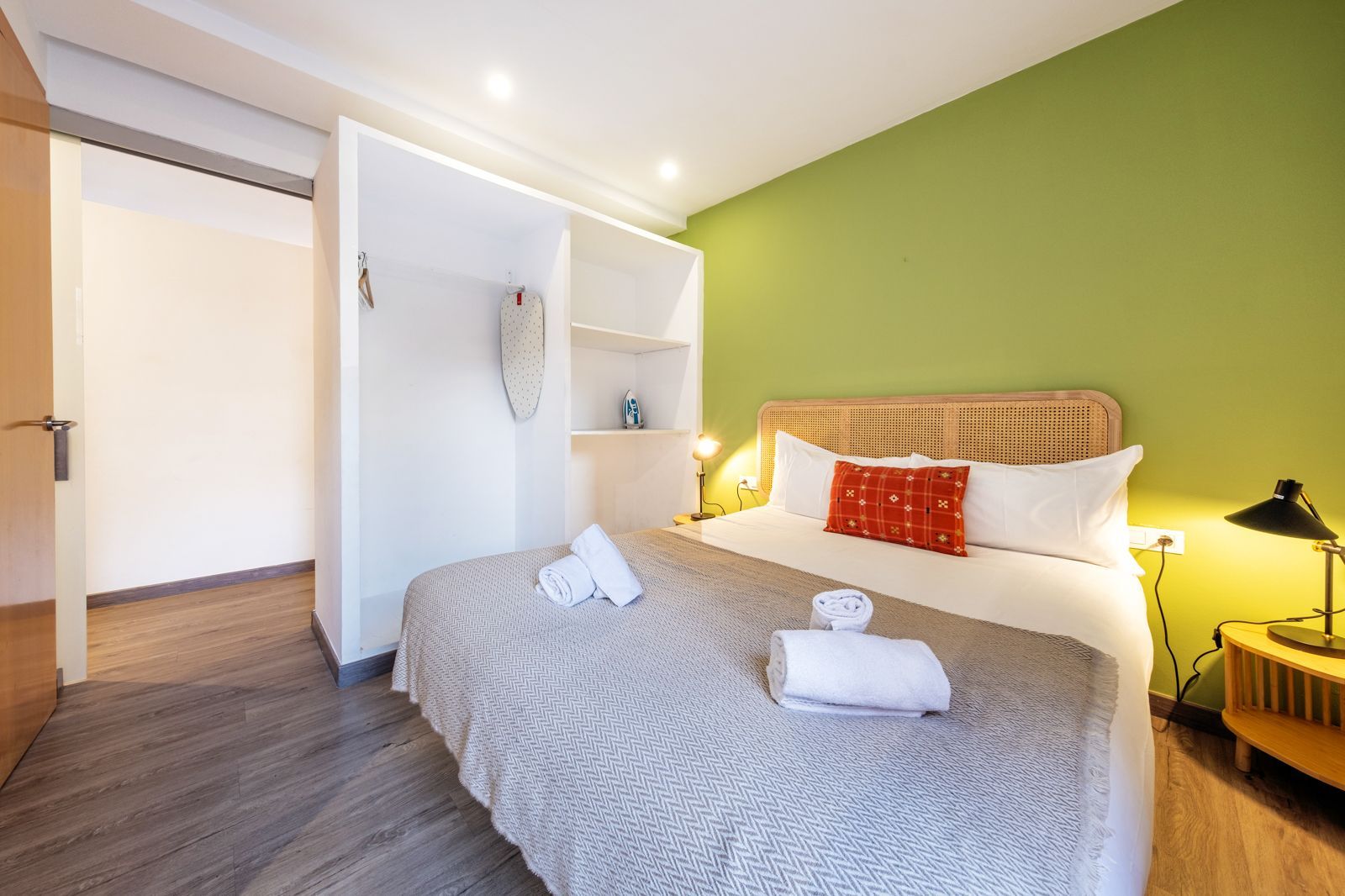 A bedroom with a king size bed and a green wall.