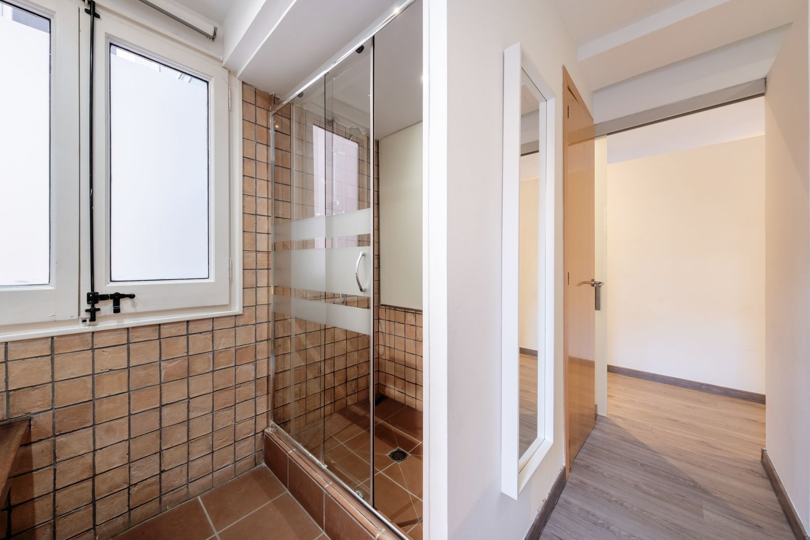 A bathroom with a walk in shower and a mirror