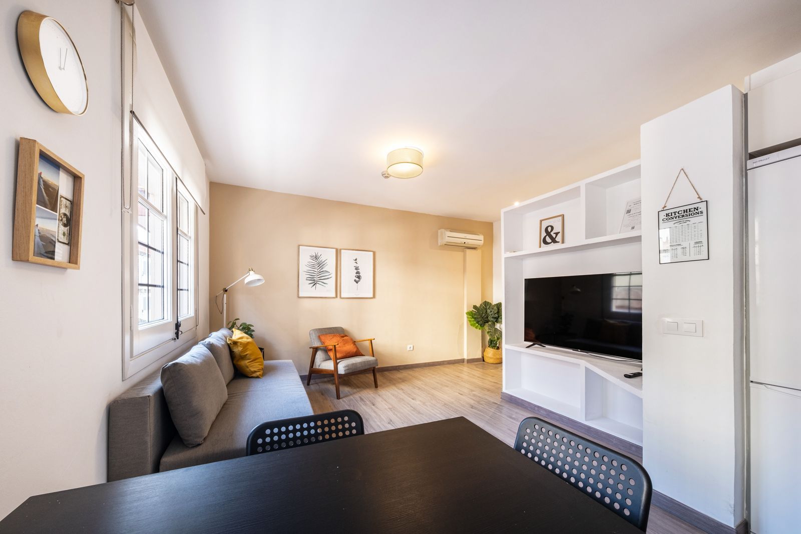 A living room with a couch , chair , table and television.