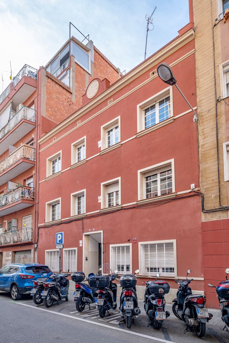 A row of scooters are parked in front of a red building