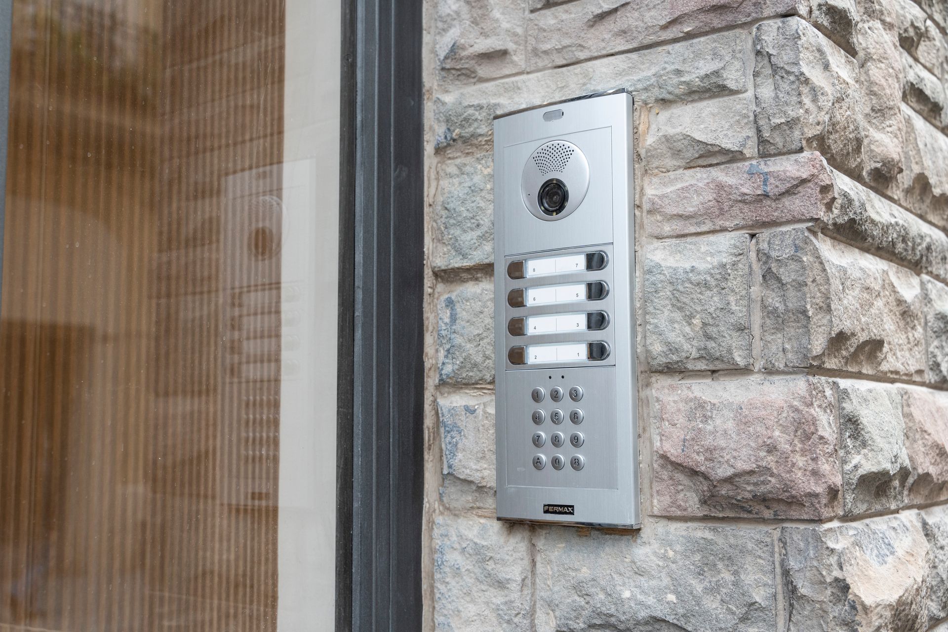 A doorbell is mounted on the side of a brick building.