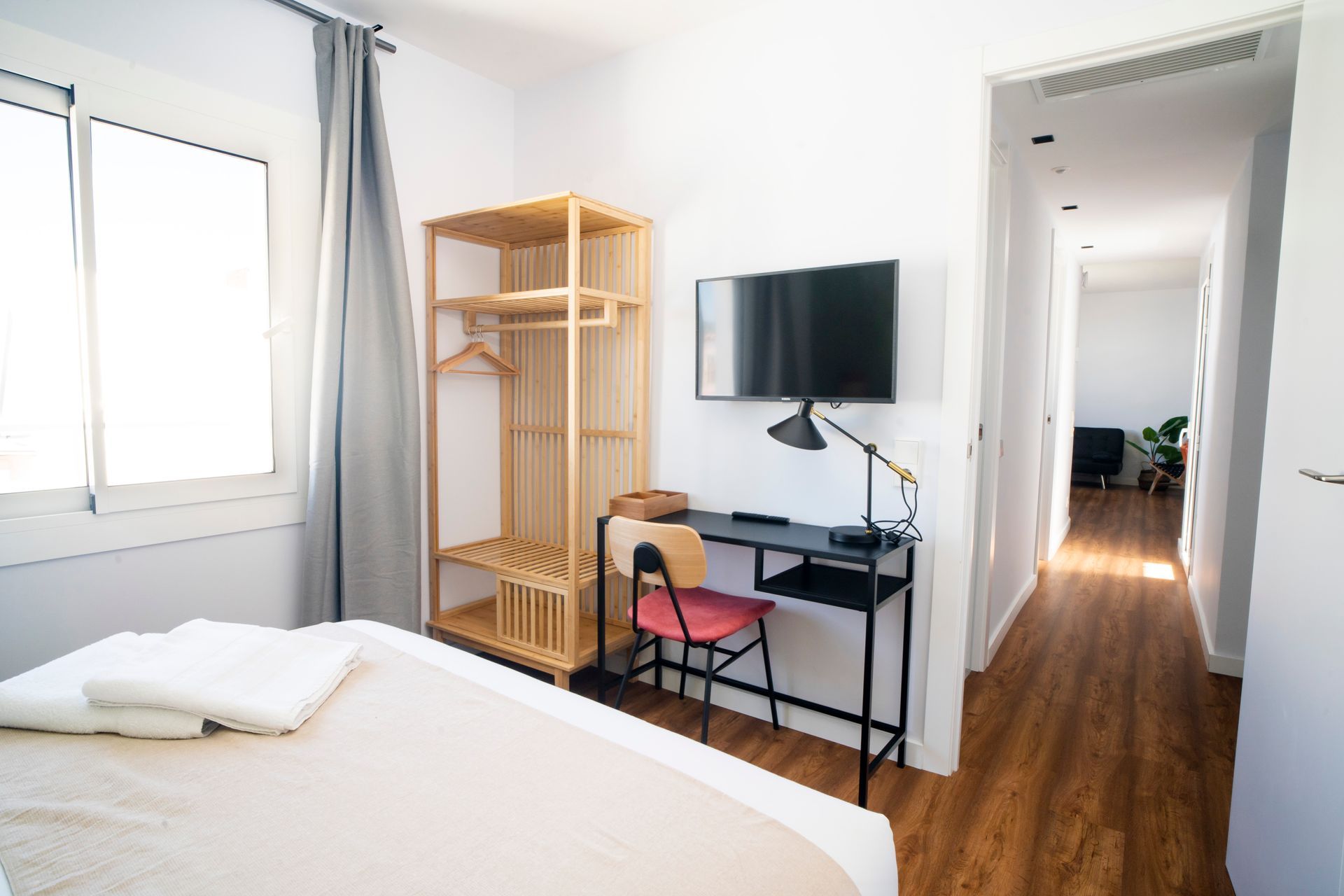 A bedroom with a bed , desk , chair and television.