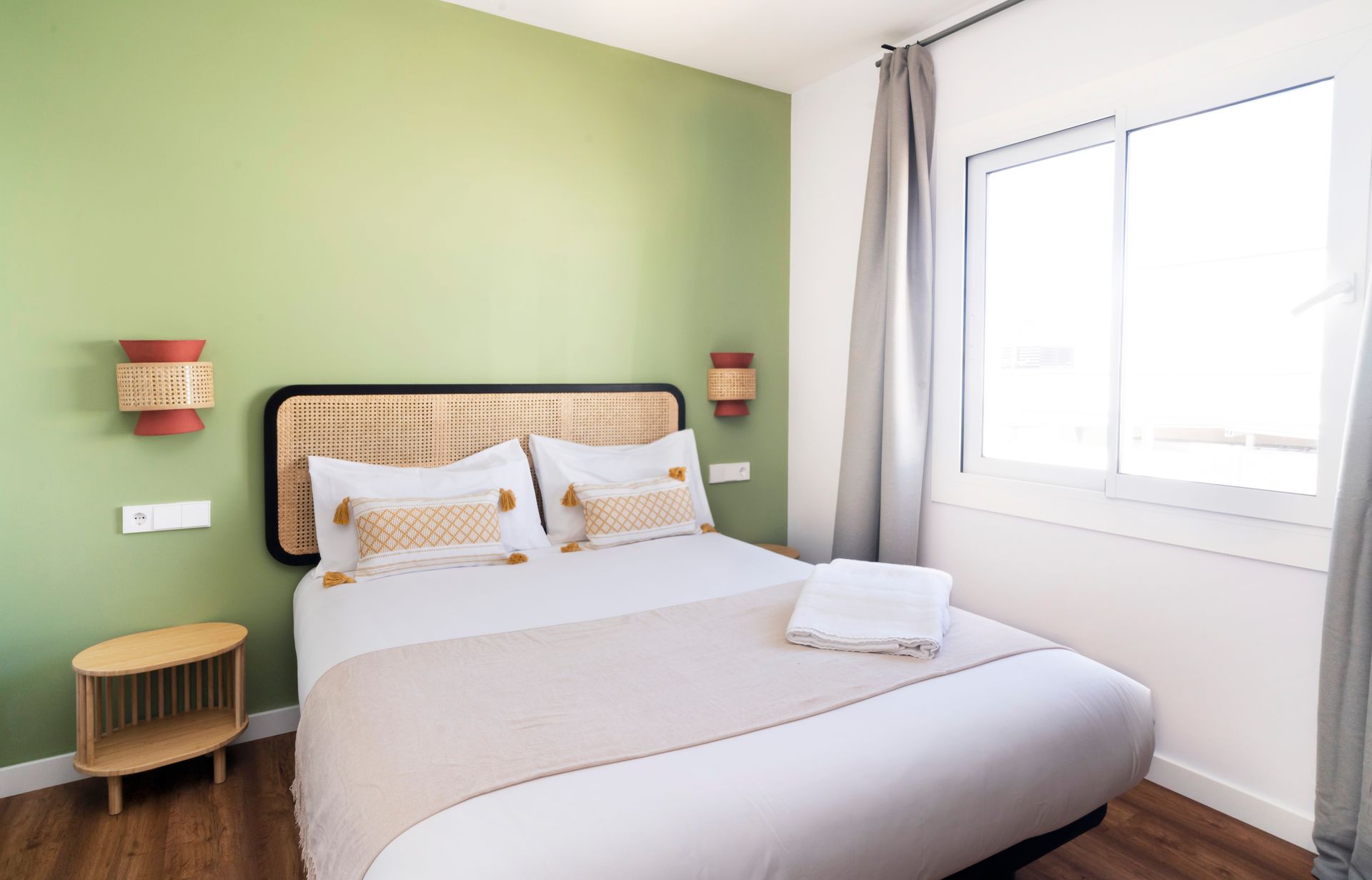 A bedroom with a bed , nightstand , and window.