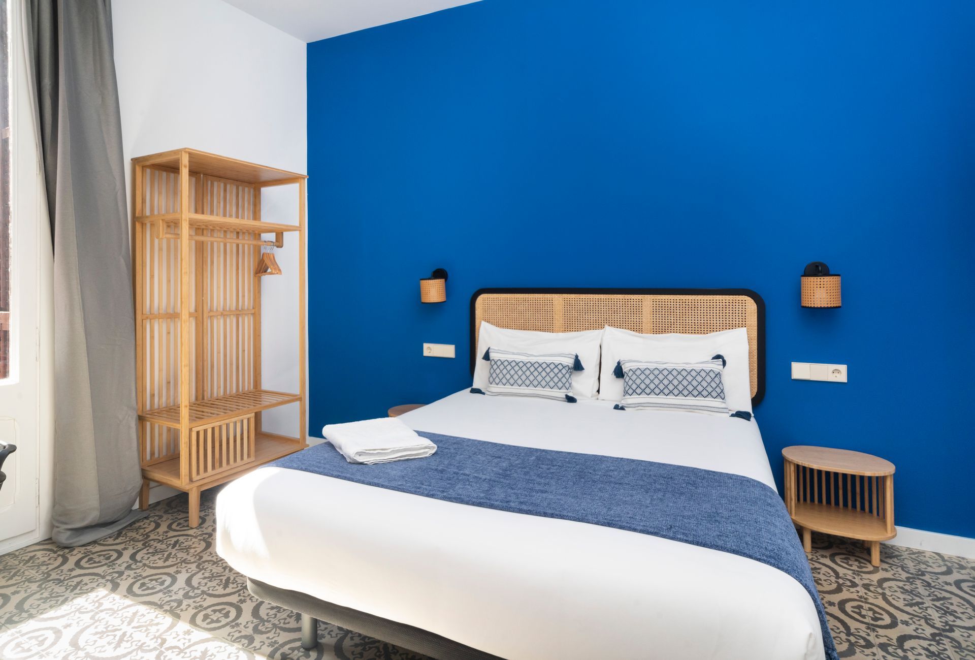 A bedroom with a blue wall and a bed.