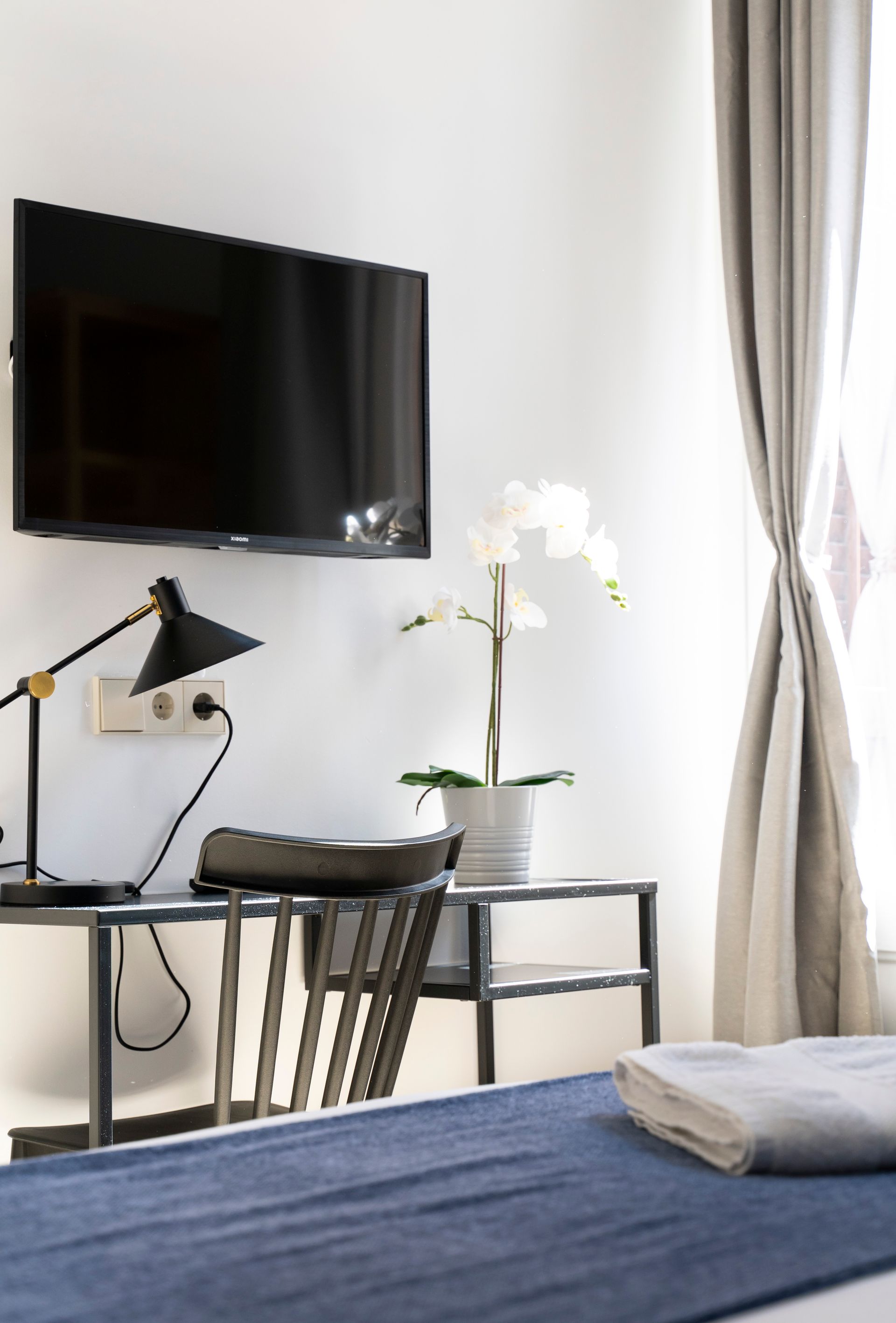 A bedroom with a flat screen tv on the wall