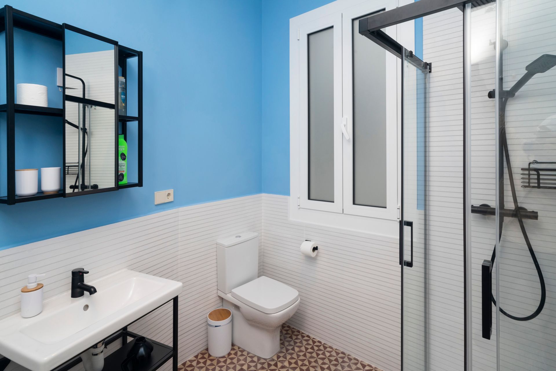 A bathroom with a toilet a sink and a shower
