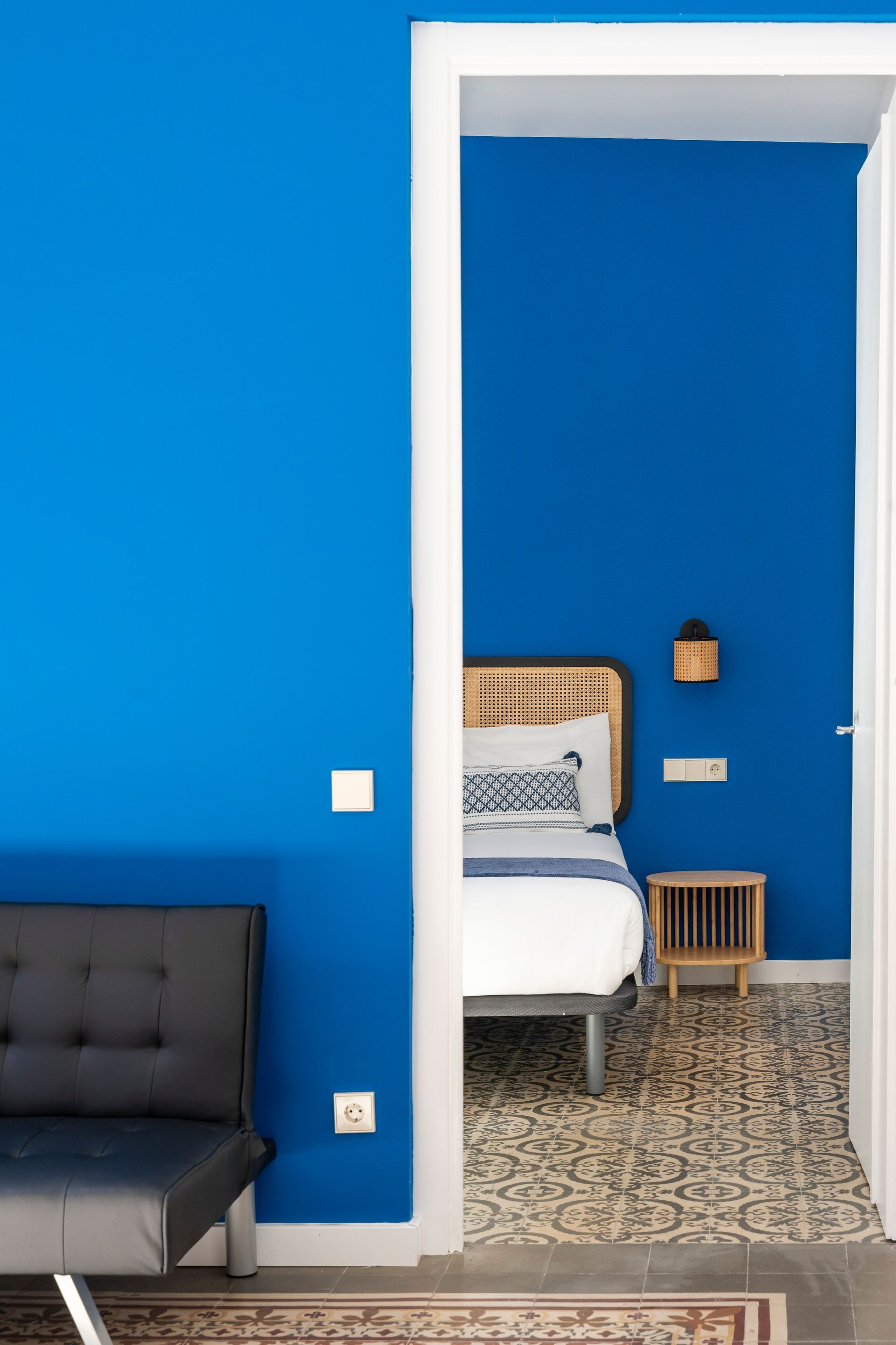 A bedroom with blue walls and a white bed