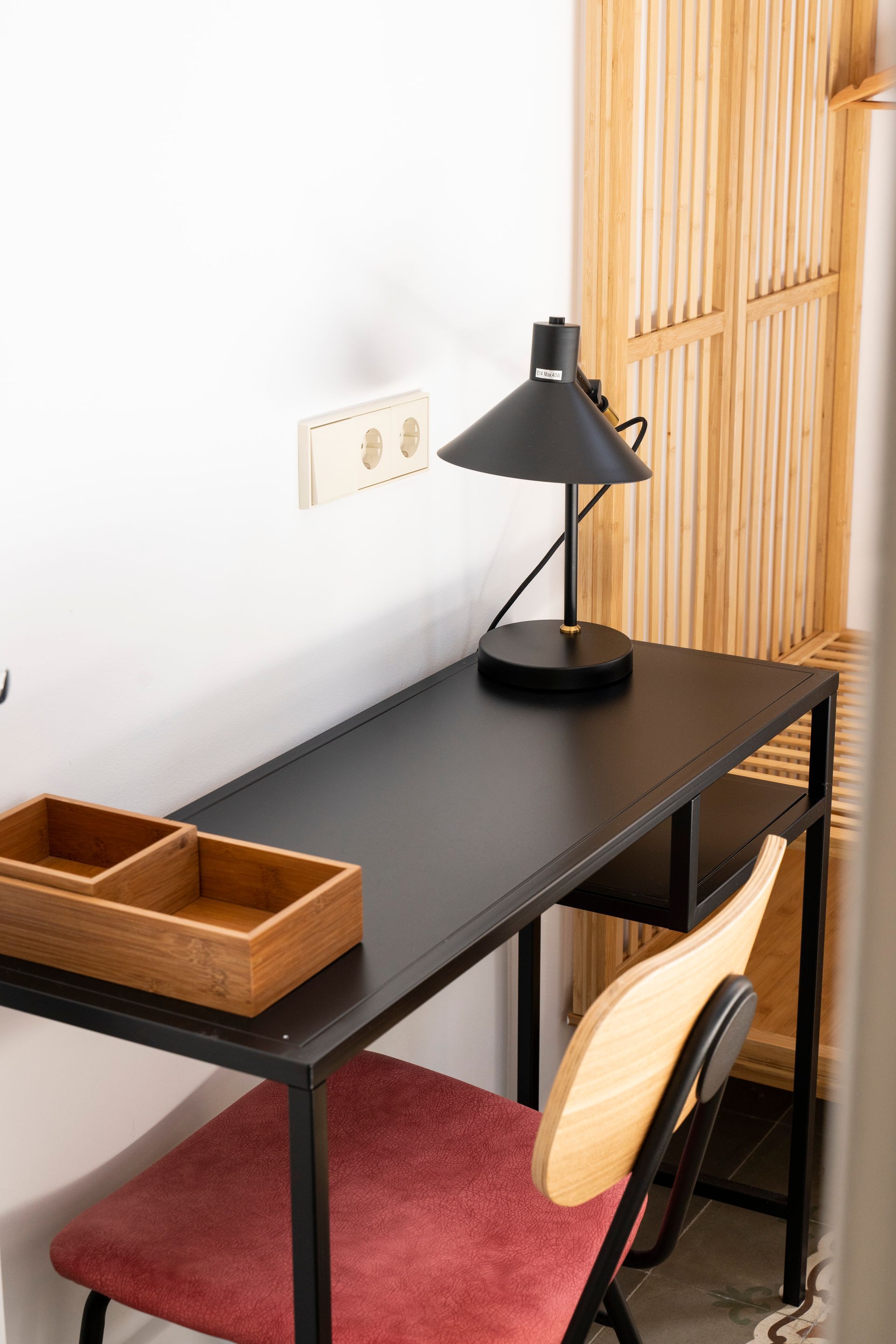 A desk with a lamp and a chair in a room.