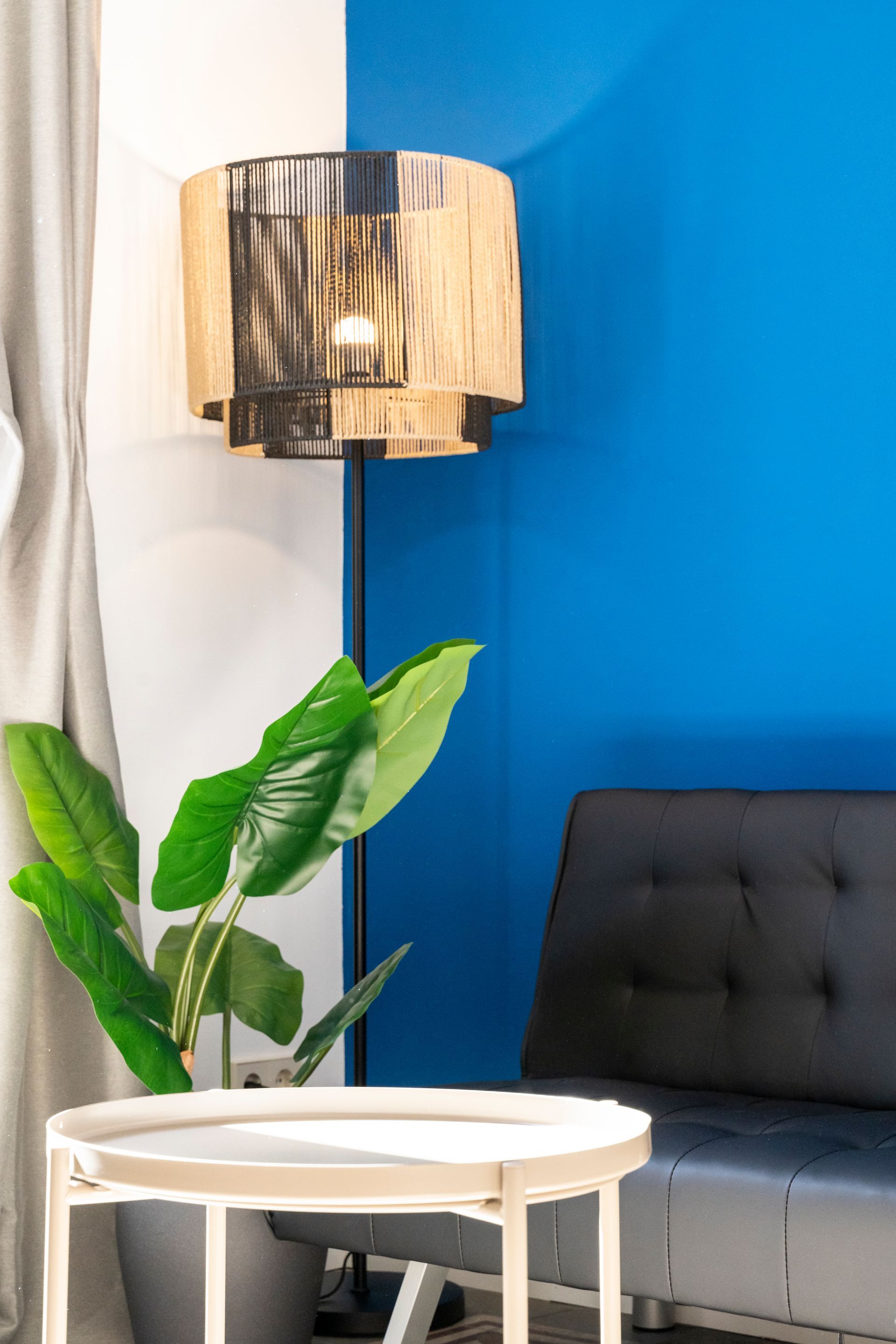 A living room with a couch , table , lamp and plant.
