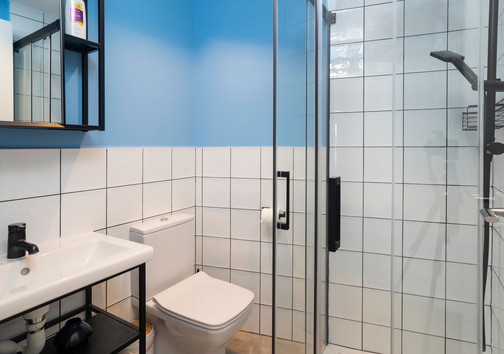A bathroom with a toilet , sink , and shower.