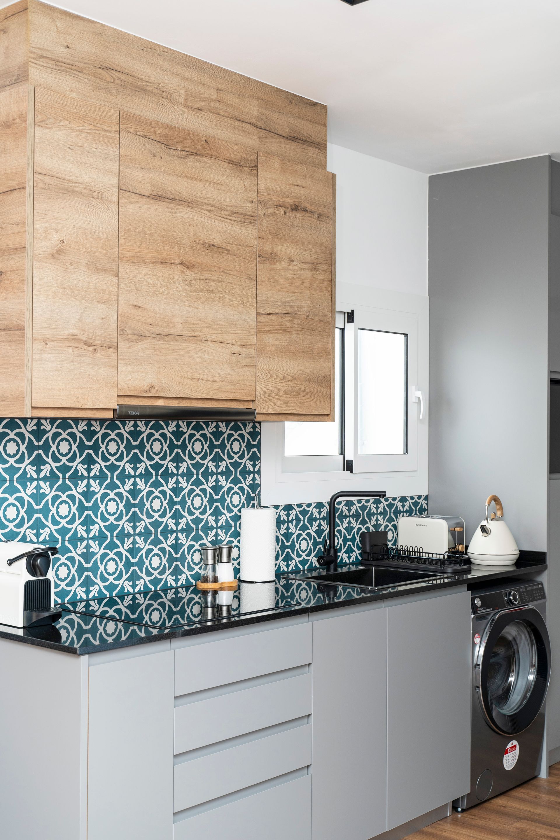 A kitchen with a washing machine and a stove top oven.