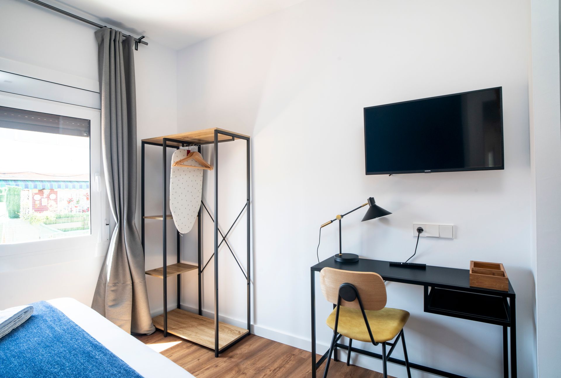 A bedroom with a desk , chair and television.