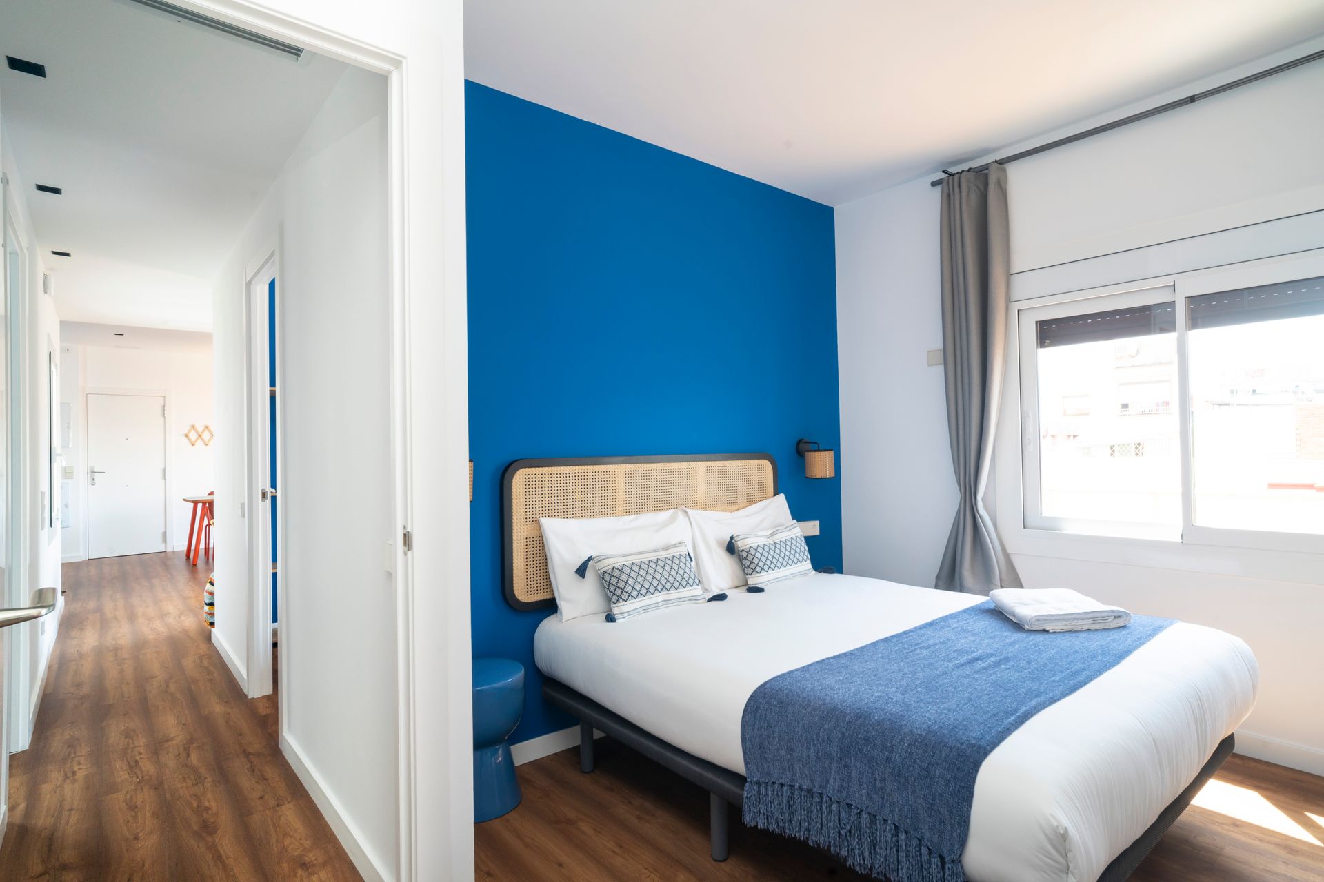 A bedroom with a large bed and a blue wall.