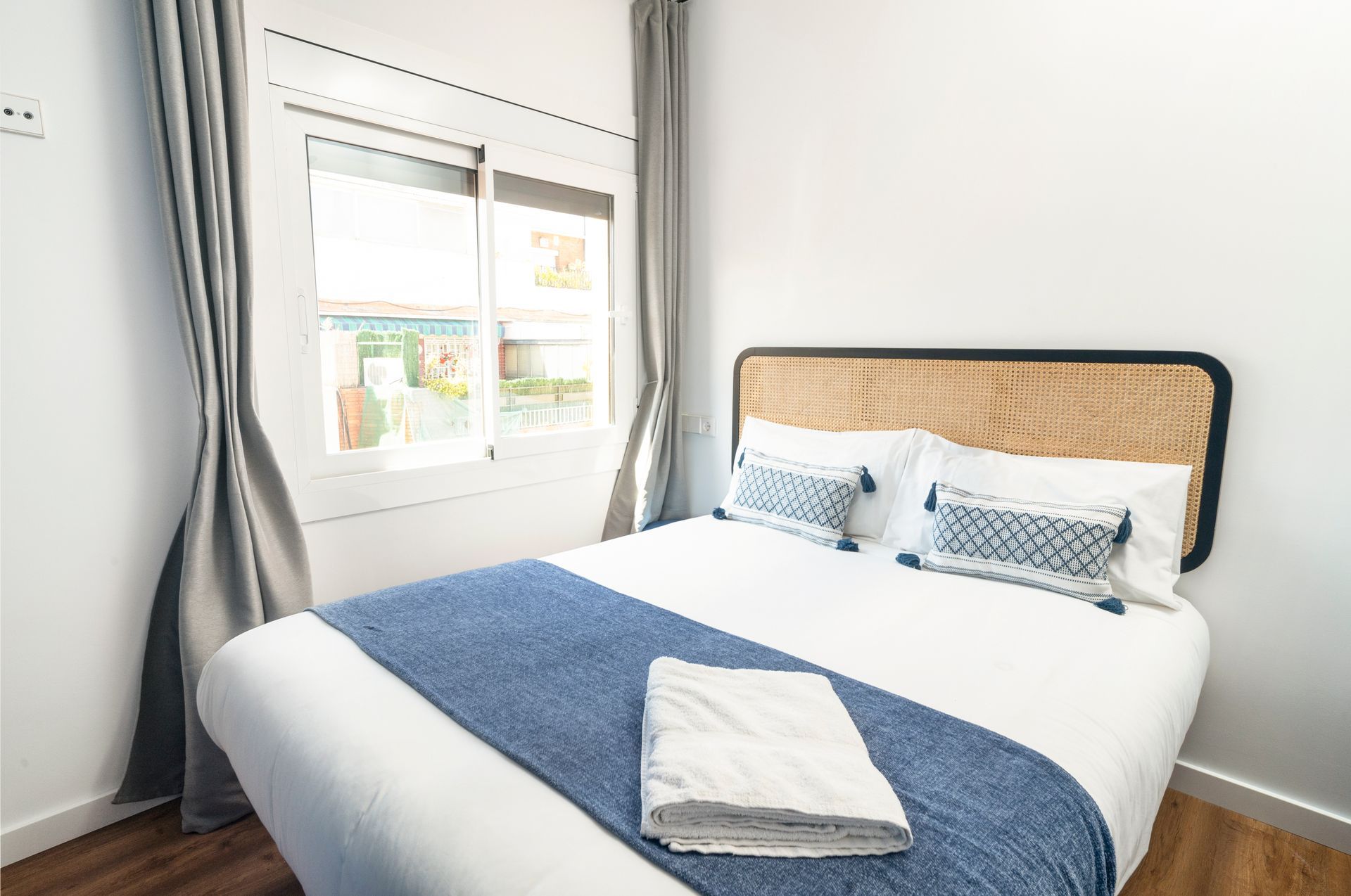 There is a bed in the middle of the room with a window.