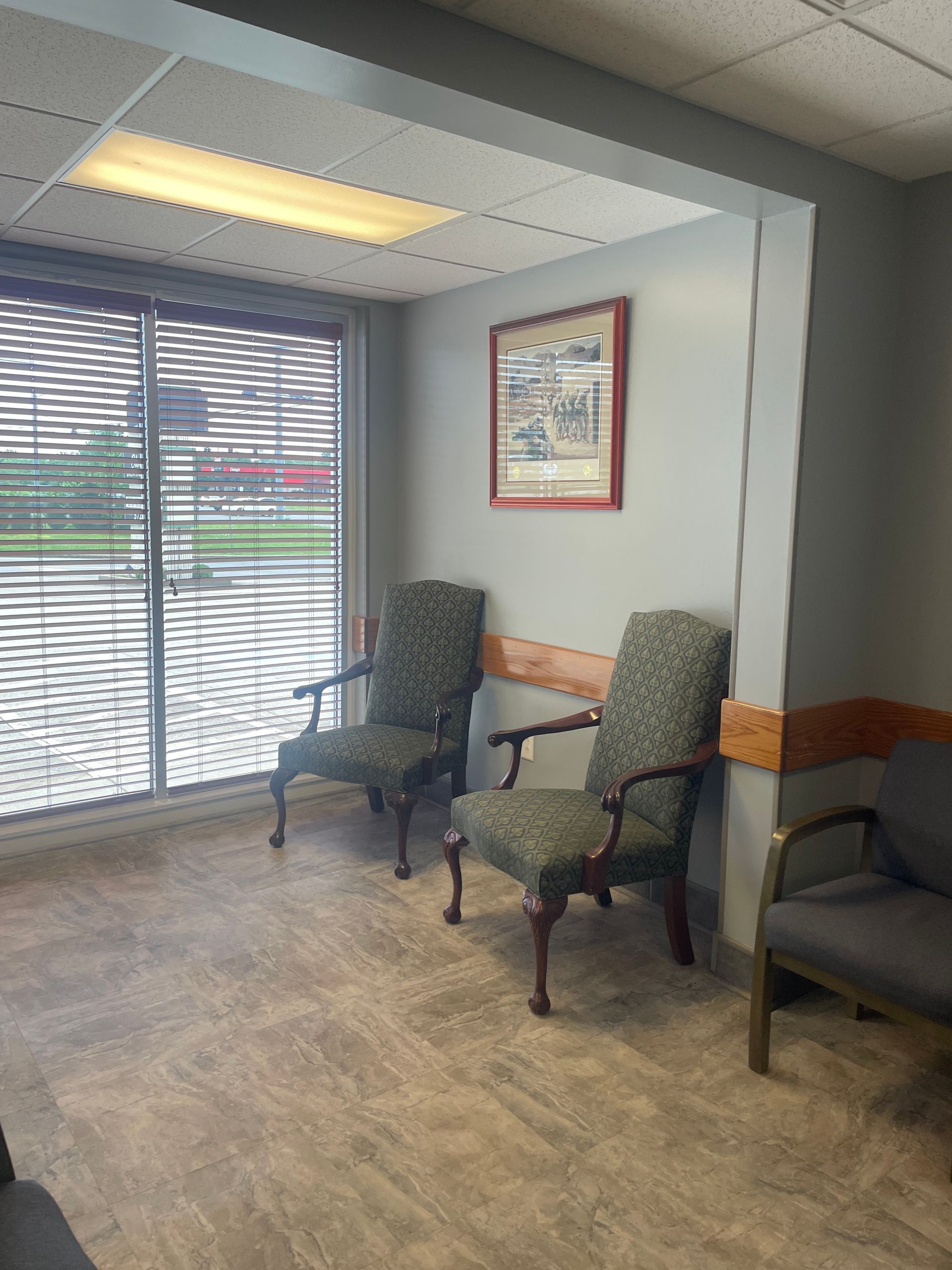 A waiting room with two chairs and a window.