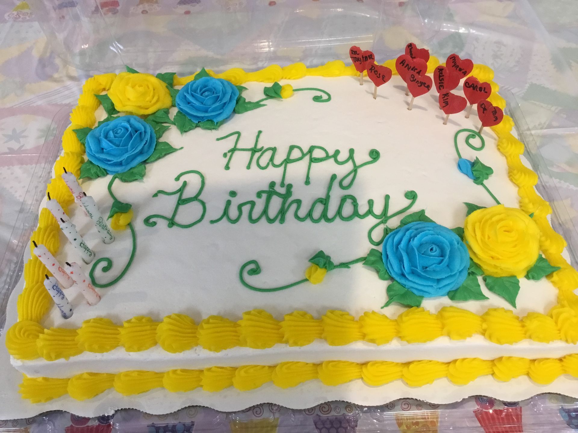 A birthday cake with yellow and blue frosting and the words happy birthday