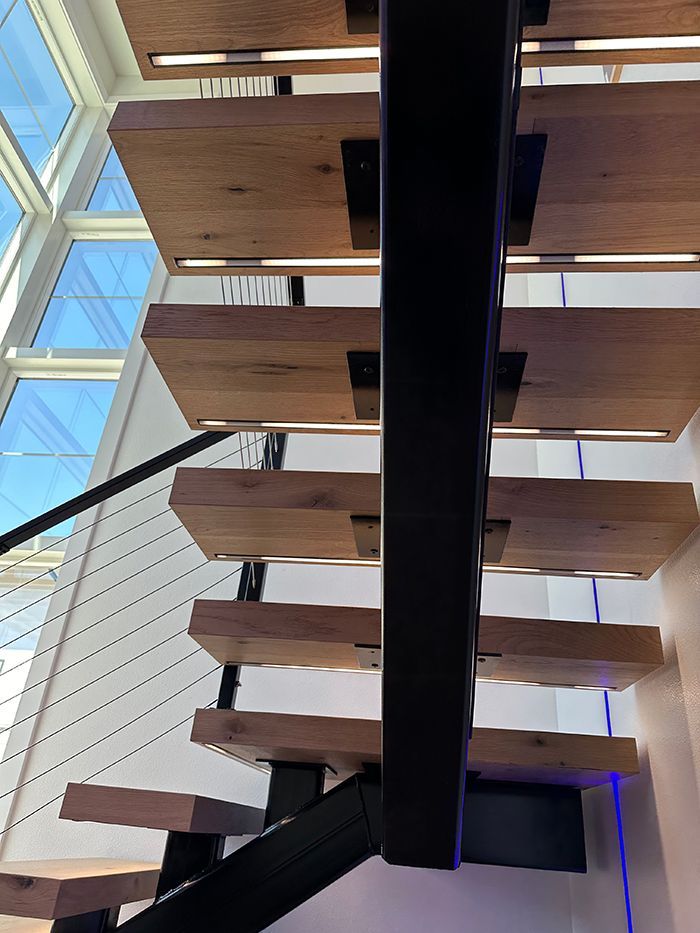 A staircase with wooden steps and a black railing