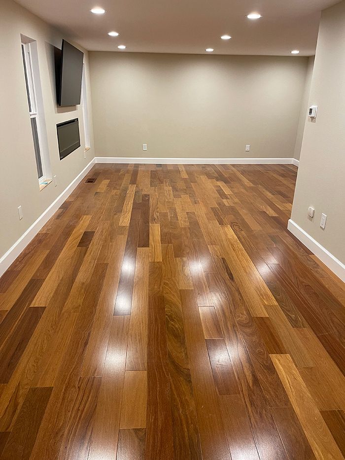 A living room with hardwood floors and a flat screen tv on the wall.
