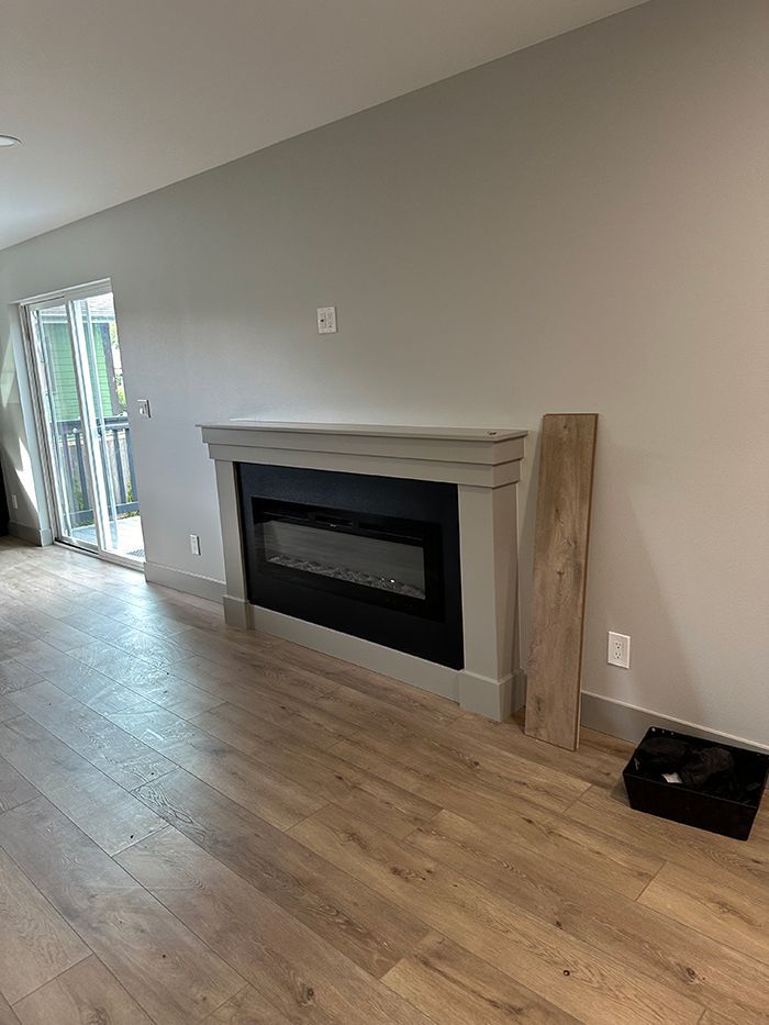 A living room with hardwood floors and a fireplace.