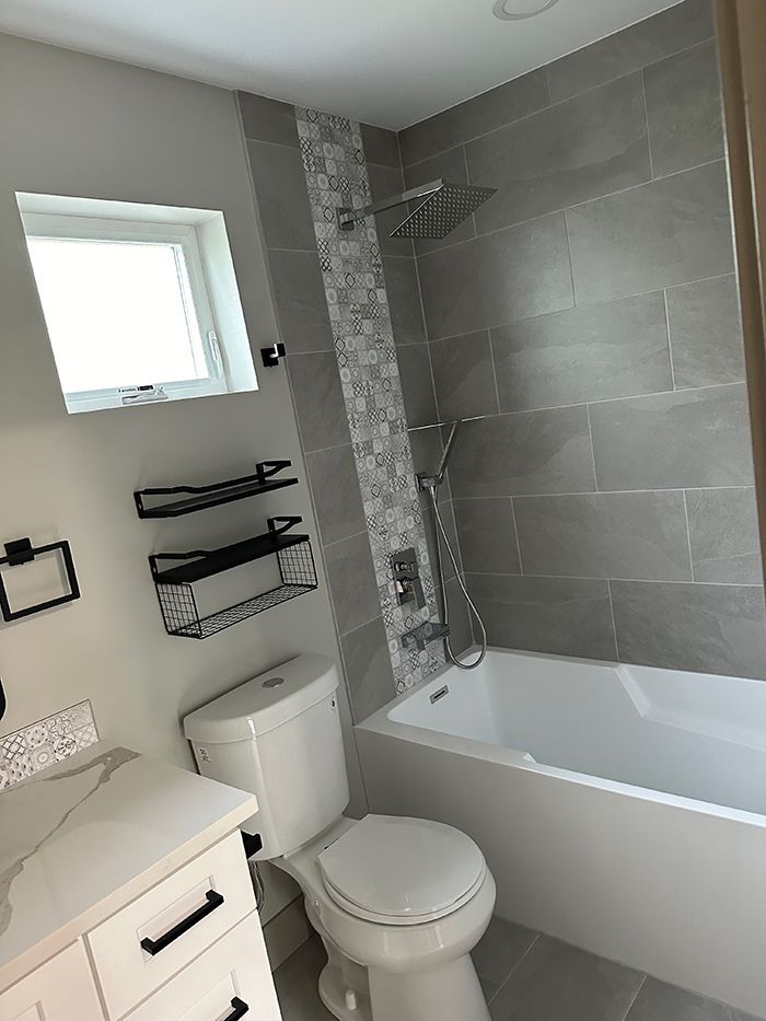 A bathroom with a toilet , bathtub and shower.