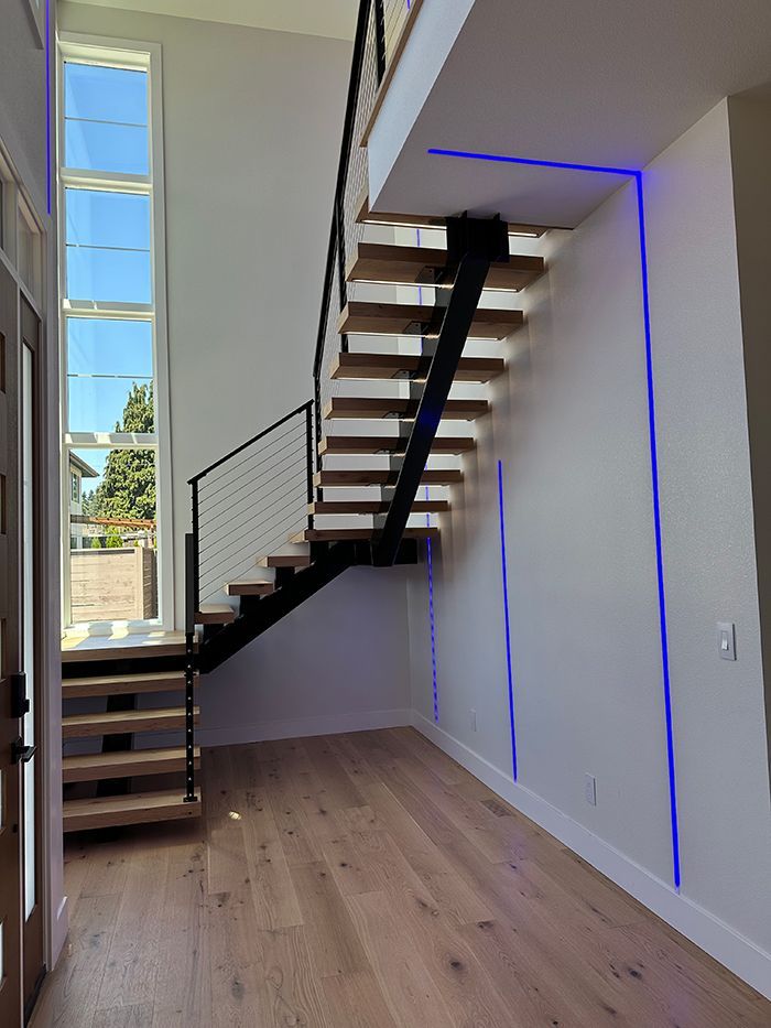 An empty hallway with a staircase and a large window.
