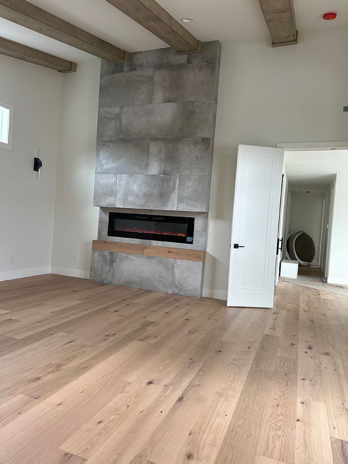 A living room with hardwood floors and a fireplace.