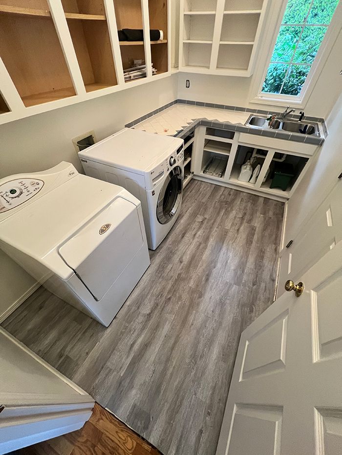 A laundry room with a washer and dryer and a sink.