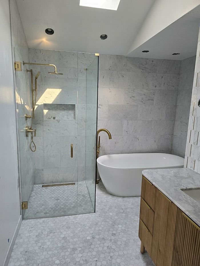 A bathroom with a bathtub , shower , and sink.