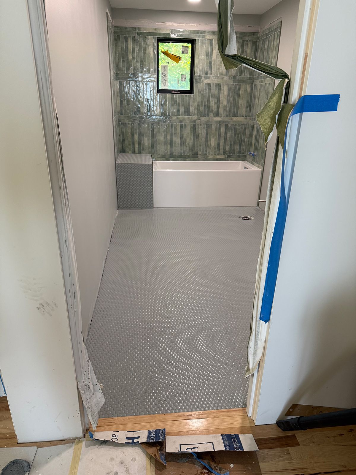 A bathroom under construction with a bathtub and tile floor.