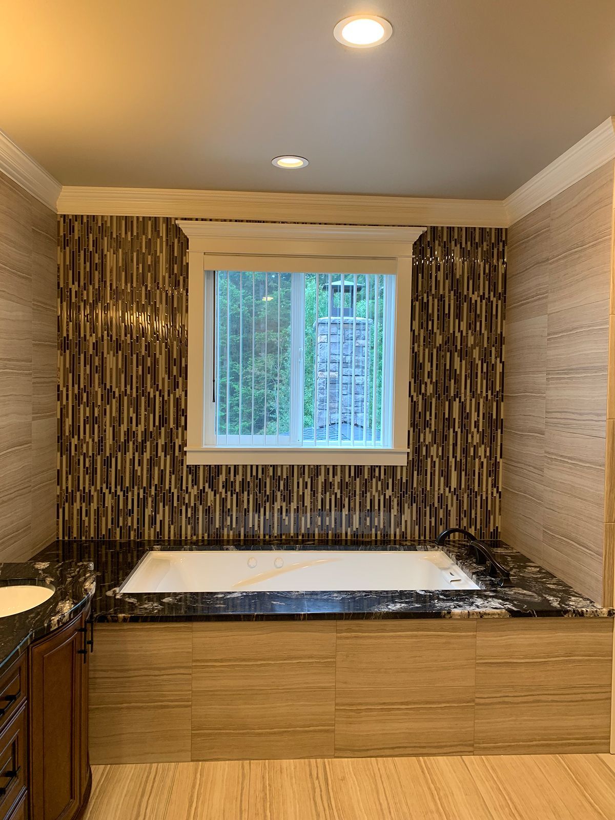 A bathroom with a large tub and a window.